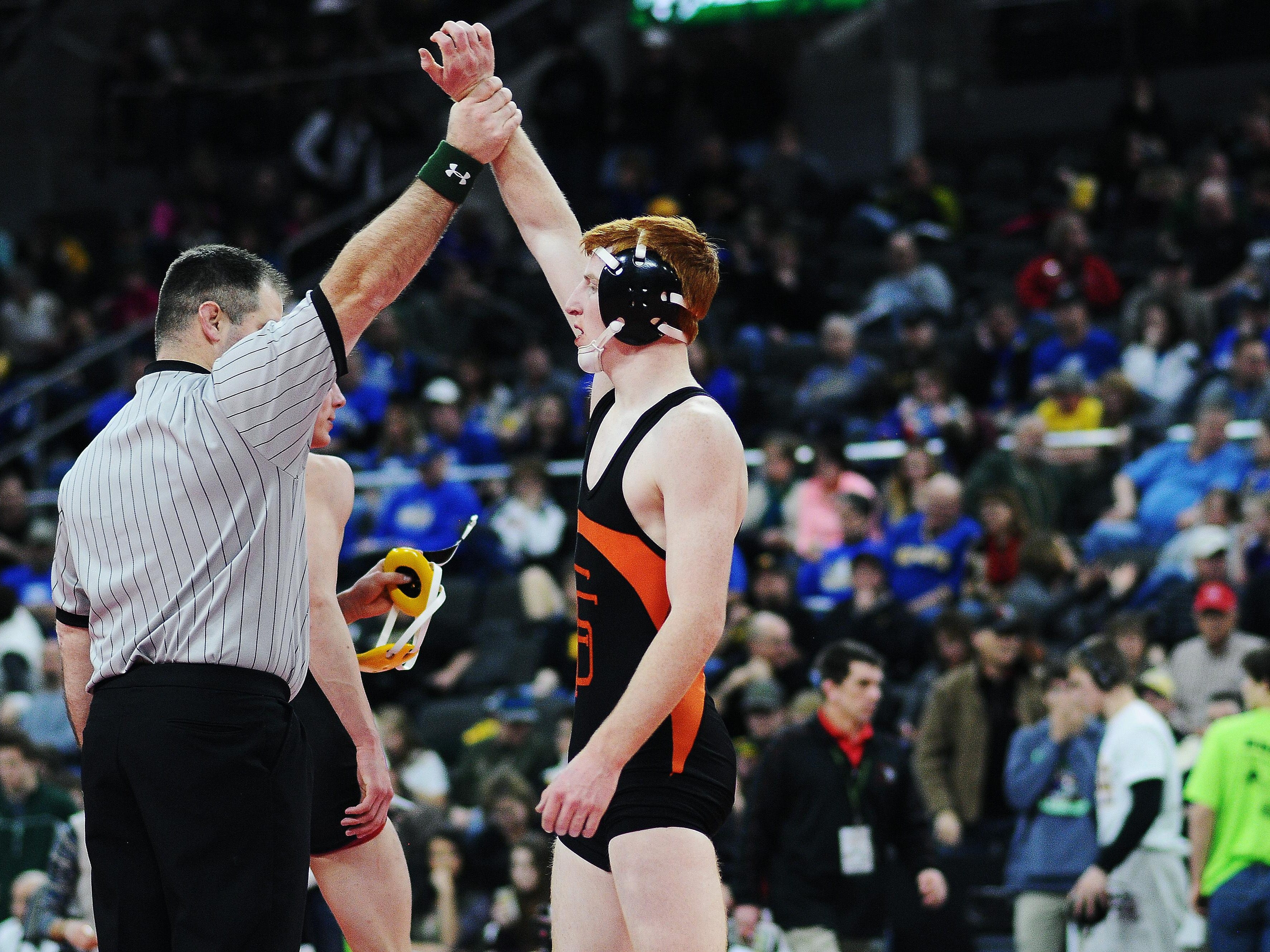 An official holds up the arm of Washington's Hunter O'Connor after he defeated Roosevelt's Carter Lohr during a 132-pound weight class match during the SDHSAA South Dakota State Class "A" Wrestling Tournament on Friday, Feb. 27, 2015, at the Denny Sanford Premier Center in Sioux Falls, S.D.
