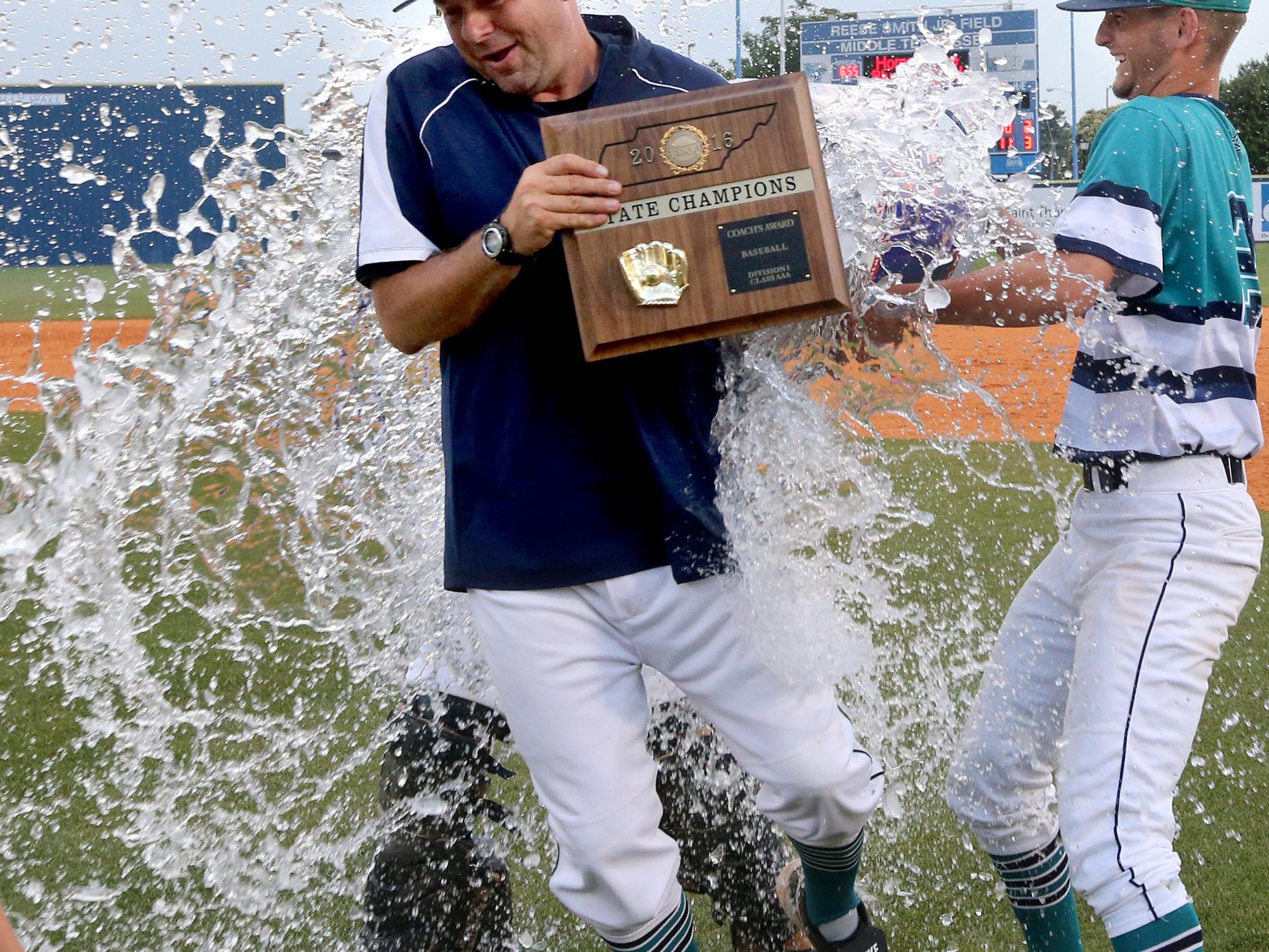 Siegel baseball coach Craig Reavis is doused by players Thomas Marks (12) and Garrett Harvey (22) after Reavis received the coaches award following the Stars’ 9-8 win over Arlington in the Class AAA championship.