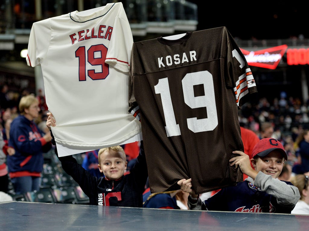 Two Cleveland Indians fans hold up jerseys of former Cleveland Indians player Bob Feller and Cleveland Browns player Bernie Kosar to signify the Indians' 19th win in a row.
