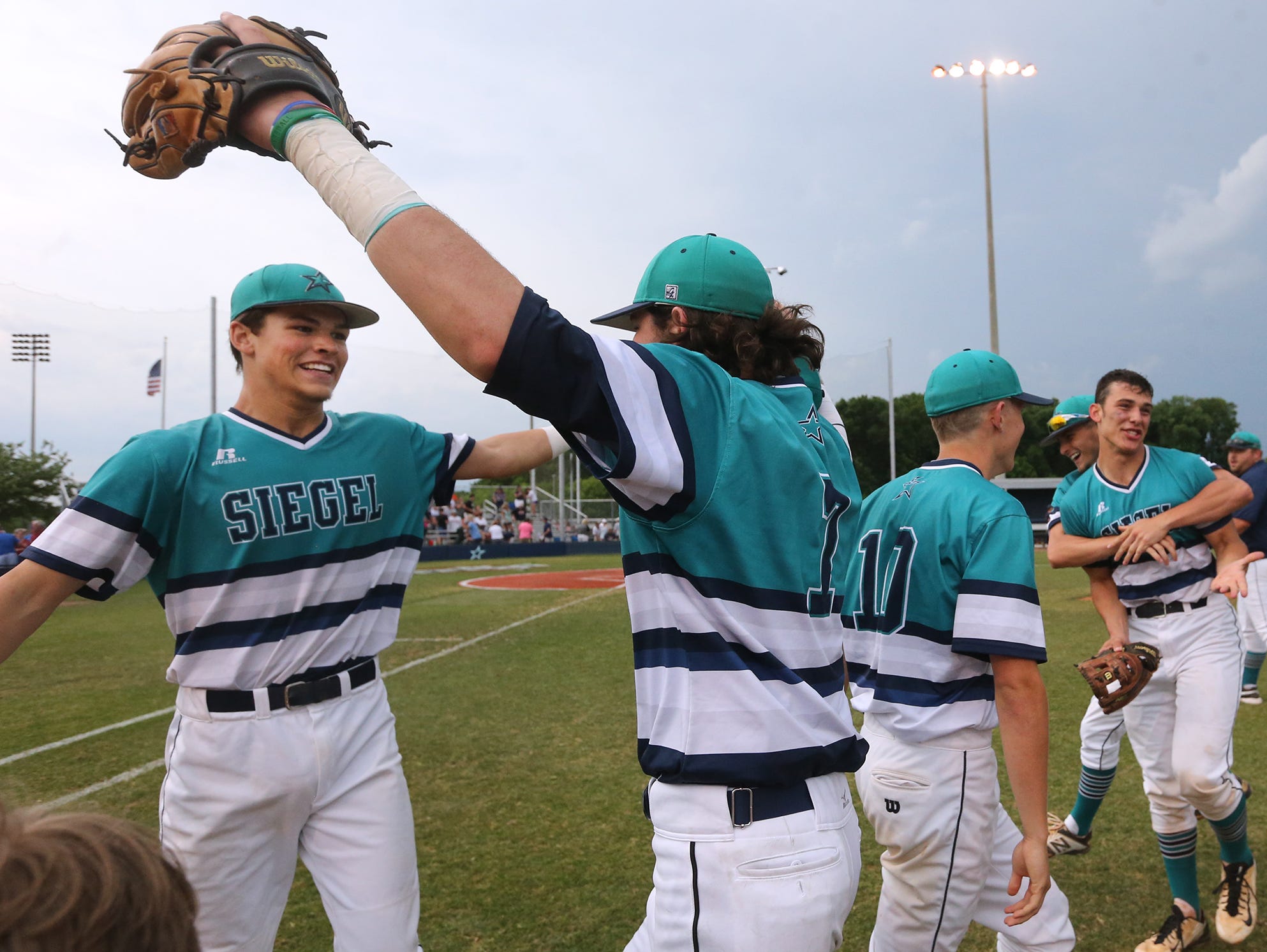 Siegel's Drew Benefiedl (24) and teammate Jordan Middleton (7) begin to hug after winning two games in a row to advance to the state championship game.