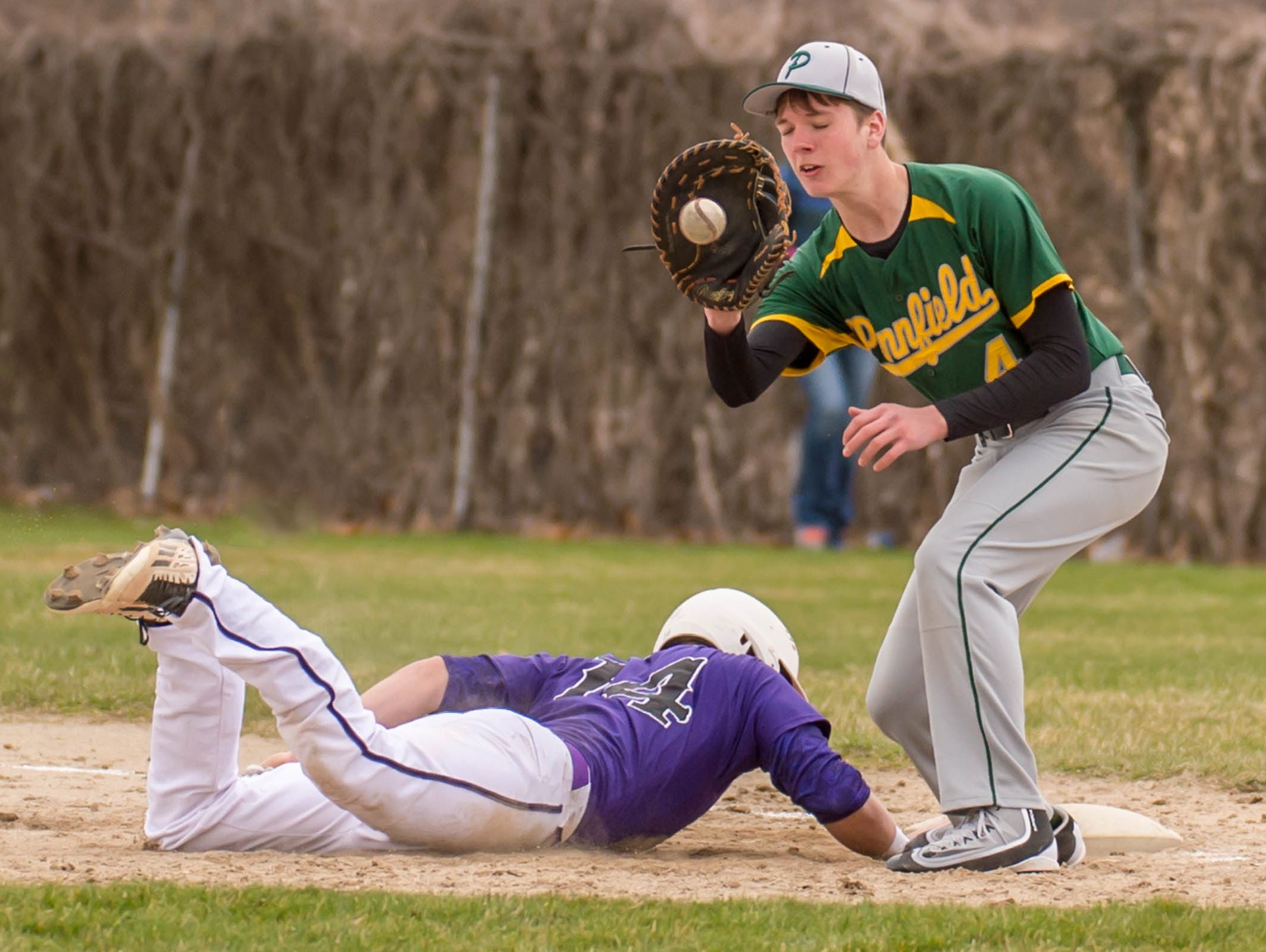 Pennfield's Logan Saxton gets the throw to first as Lakeview's Skyler Nichols (14) slides back safe.