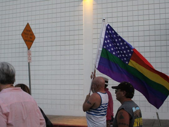 Paul Green, center, holds up a flag as he and others