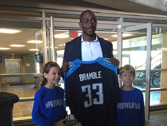 Titans marketing coordinator Toks Sokoya presented Baylor Bramble's siblings Macy and Brady a Titans jersey and a signed mini helmet on Tuesday.
