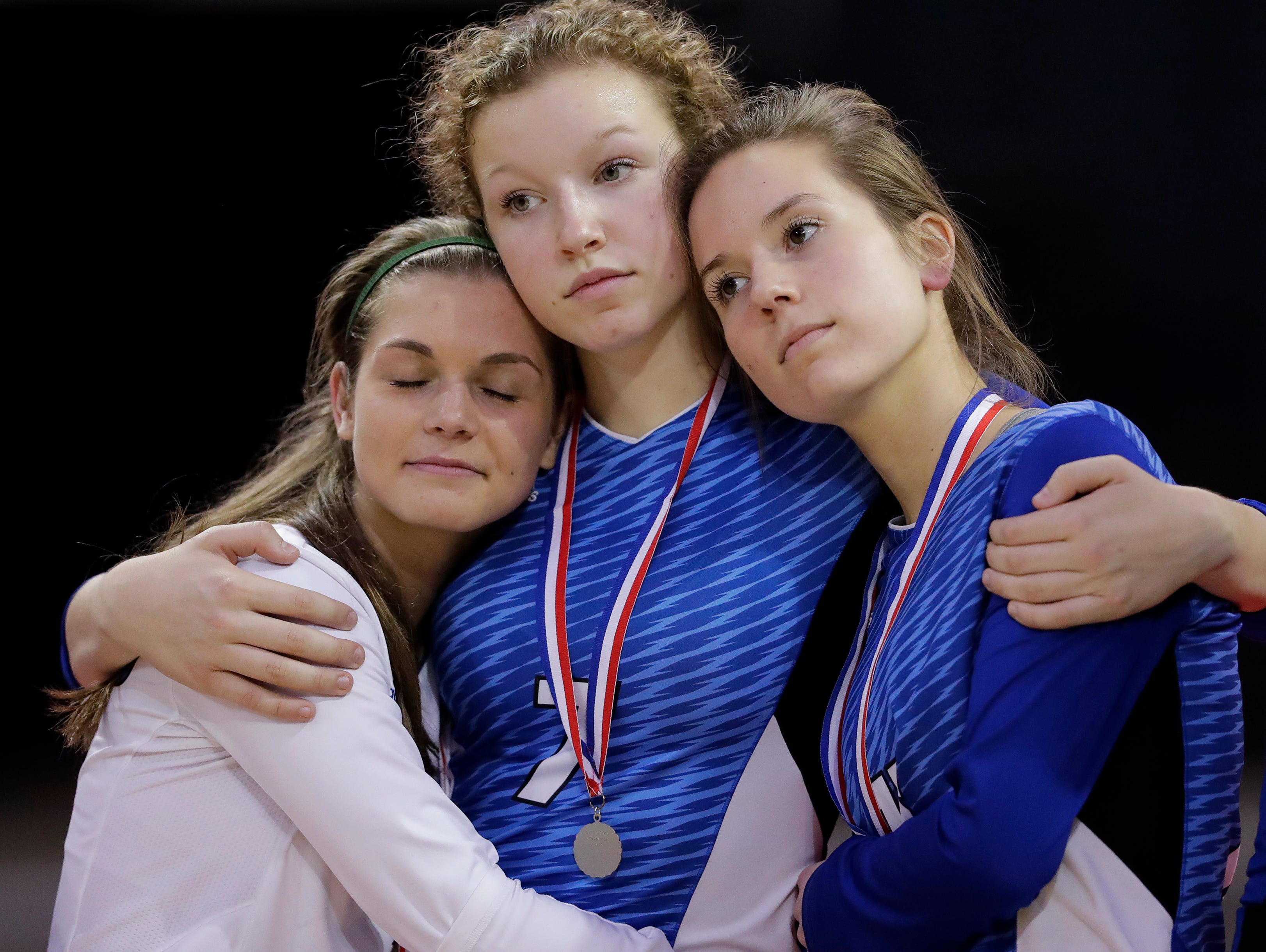 From left: Notre Dame's Whitney DeMeuse (1), Maddie Reitz (7), and Meghan Yakel (13) embrace after the Tritons lost to Waukesha Catholic Memorial in the Division 2 championship match at the WIAA state girls volleyball tournament at the Resch Center on Nov. 5.