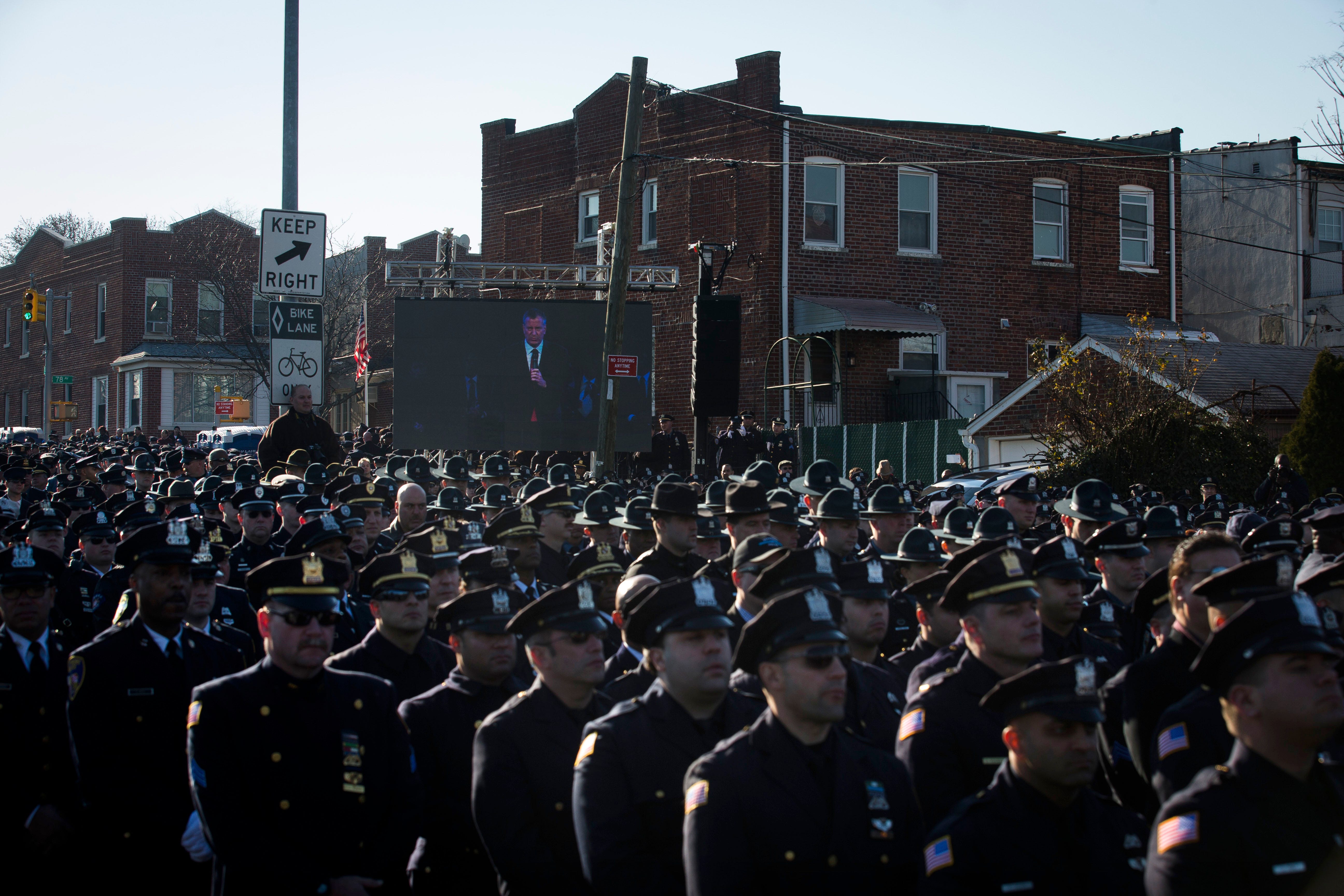 De Blasio speaks at funeral; officers turn their backs