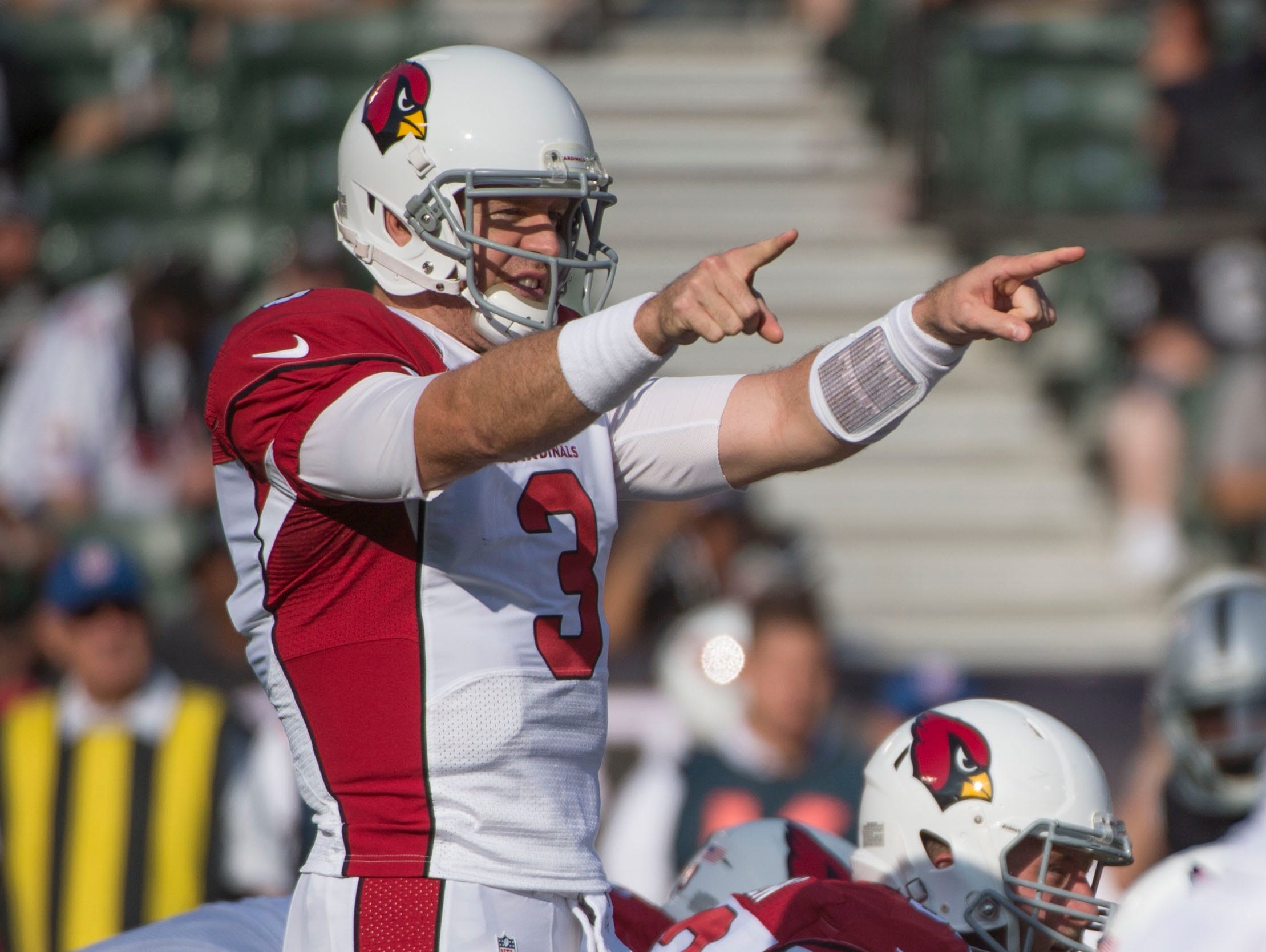 Cardinals quarterback Carson Palmer directs the offense at the line of scrimmage during the first quarter against the Raiders in Oakland.
