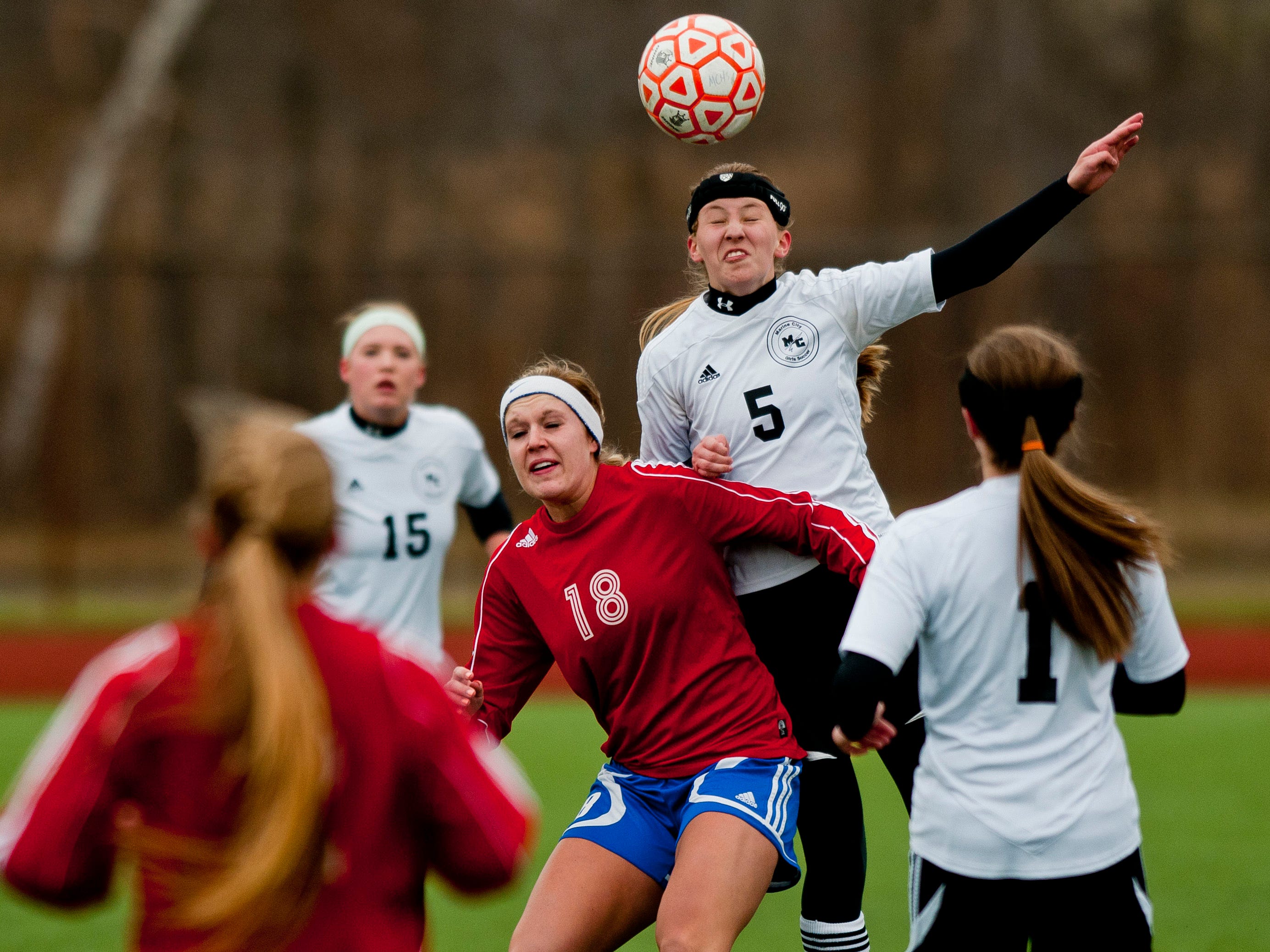 Marine City's Emilie Andrews heads the ball over St. Clair's Mackenzie Kent during a soccer game Wednesday at East China Stadium.