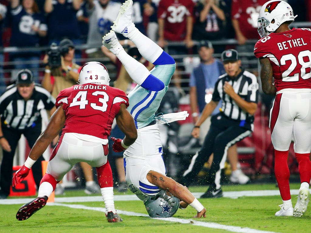 Dallas Cowboys quarterback Zac Dysert  scores a touchdown ahead of Arizona Cardinals inside linebacker Haason Reddick during the second quarter at University of Phoenix Stadium in Glendale, Ariz.