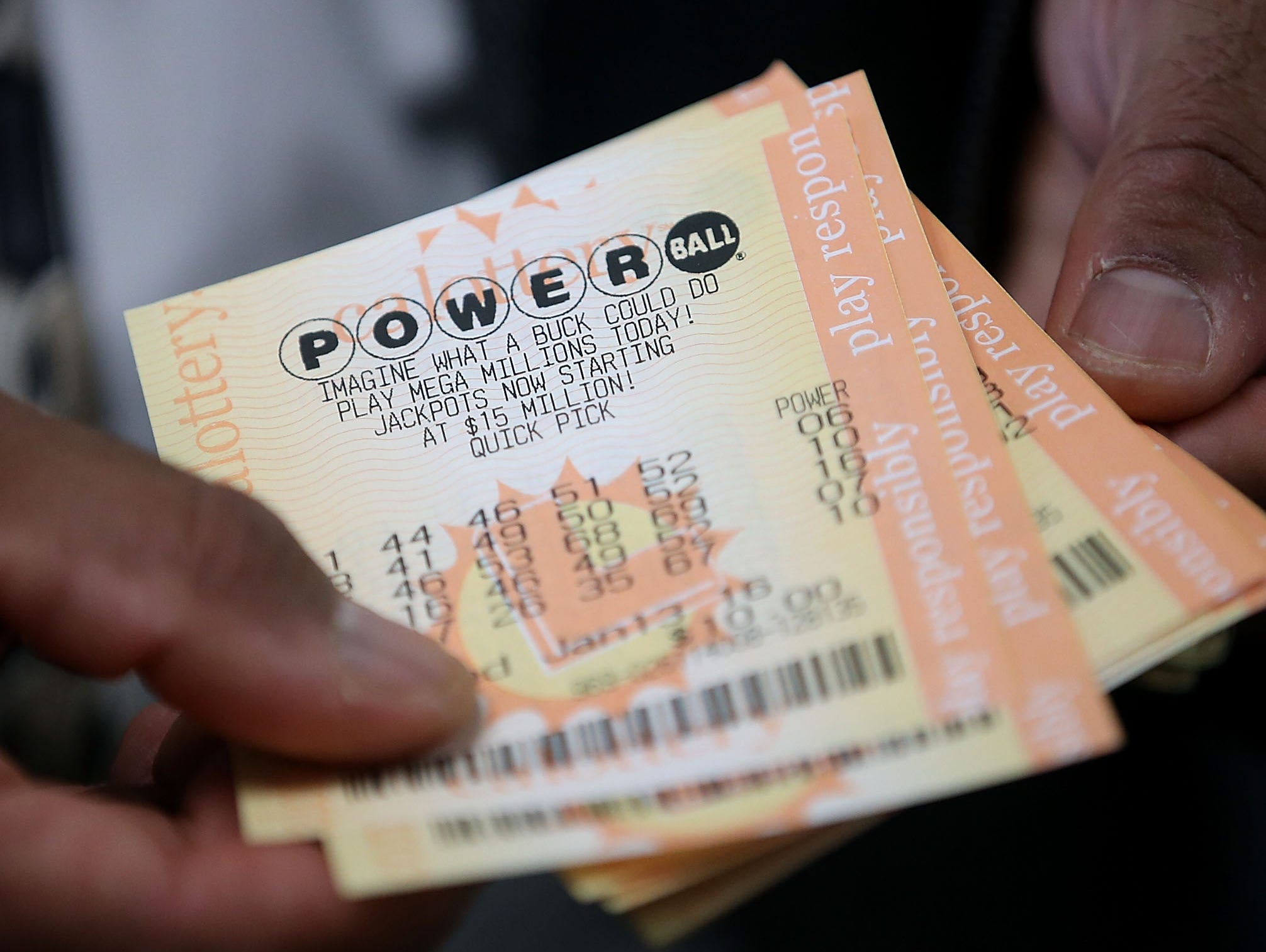 A customer holds Powerball tickets that he purchased Jan. 12, 2016, at Kavanagh Liquors in San Lorenzo, Calif.