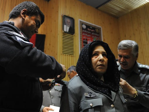 A female Afghan police officer is decorated during