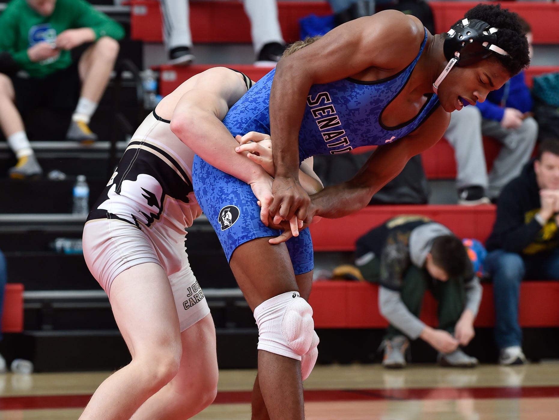 Dover's Timothy Horvath, right tries to get away from John Carroll's Andy Millner in the 152 pound championship match at the Eagle Classic wrestling tournament at Smyrna High School.