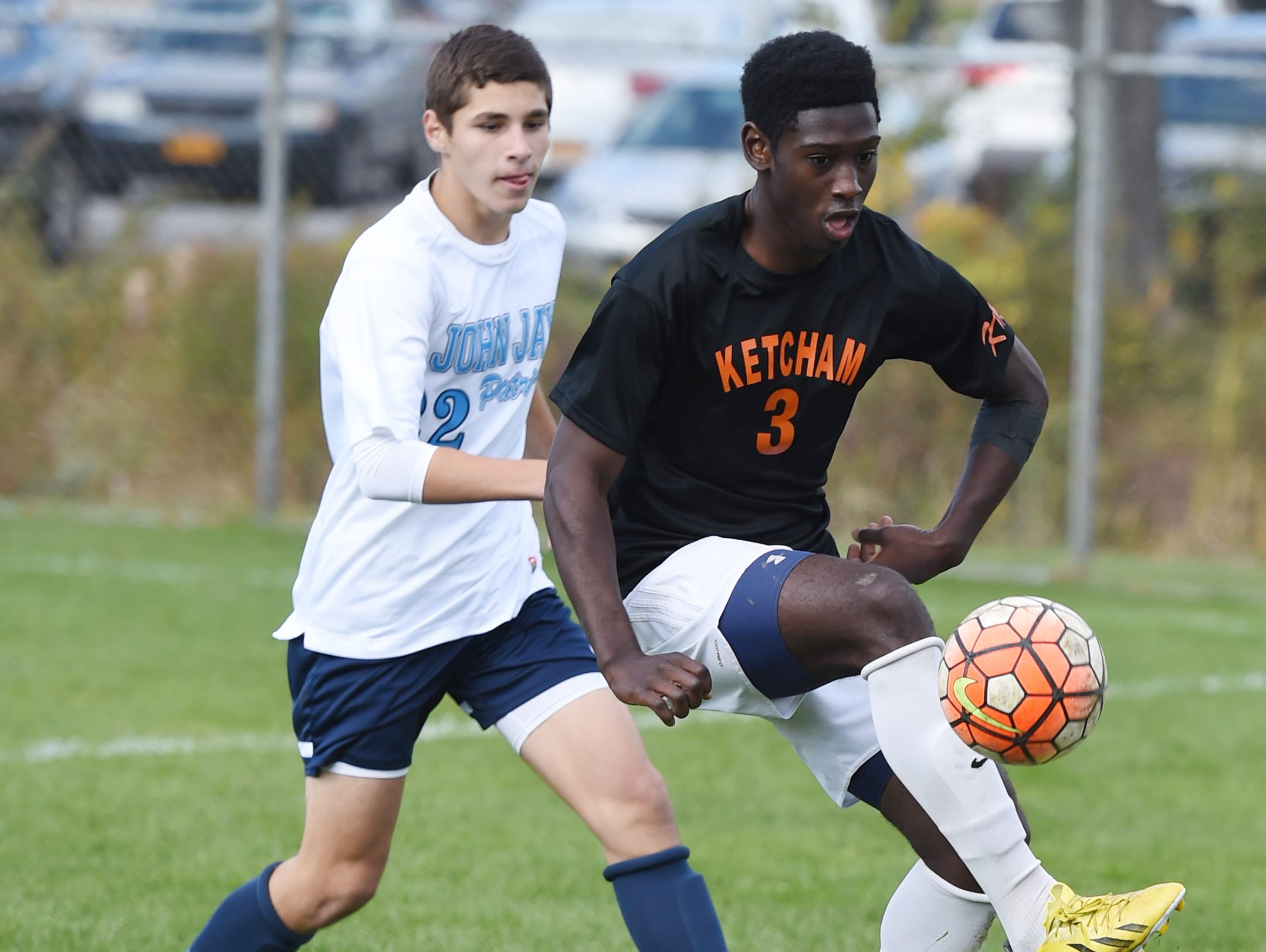 Ketcham's Eddie Armah gets the ball under control as John Jay's Michael Fino moves in on him during Saturday's game in Wappingers Falls.