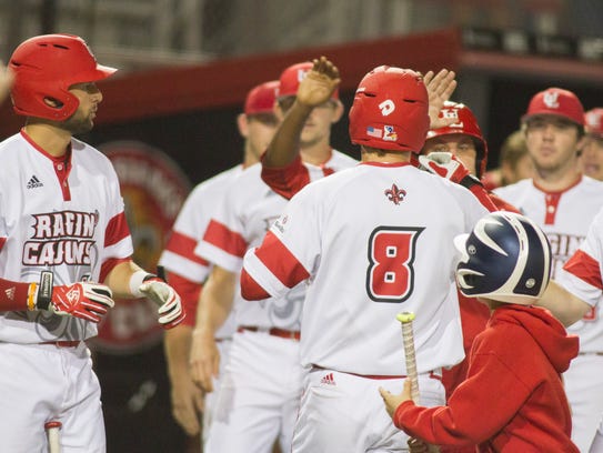 UL's Derek Herrington (8) is congratulated by teammates