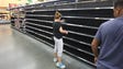 A consumer grabs the last loaf of bread at a supermarket