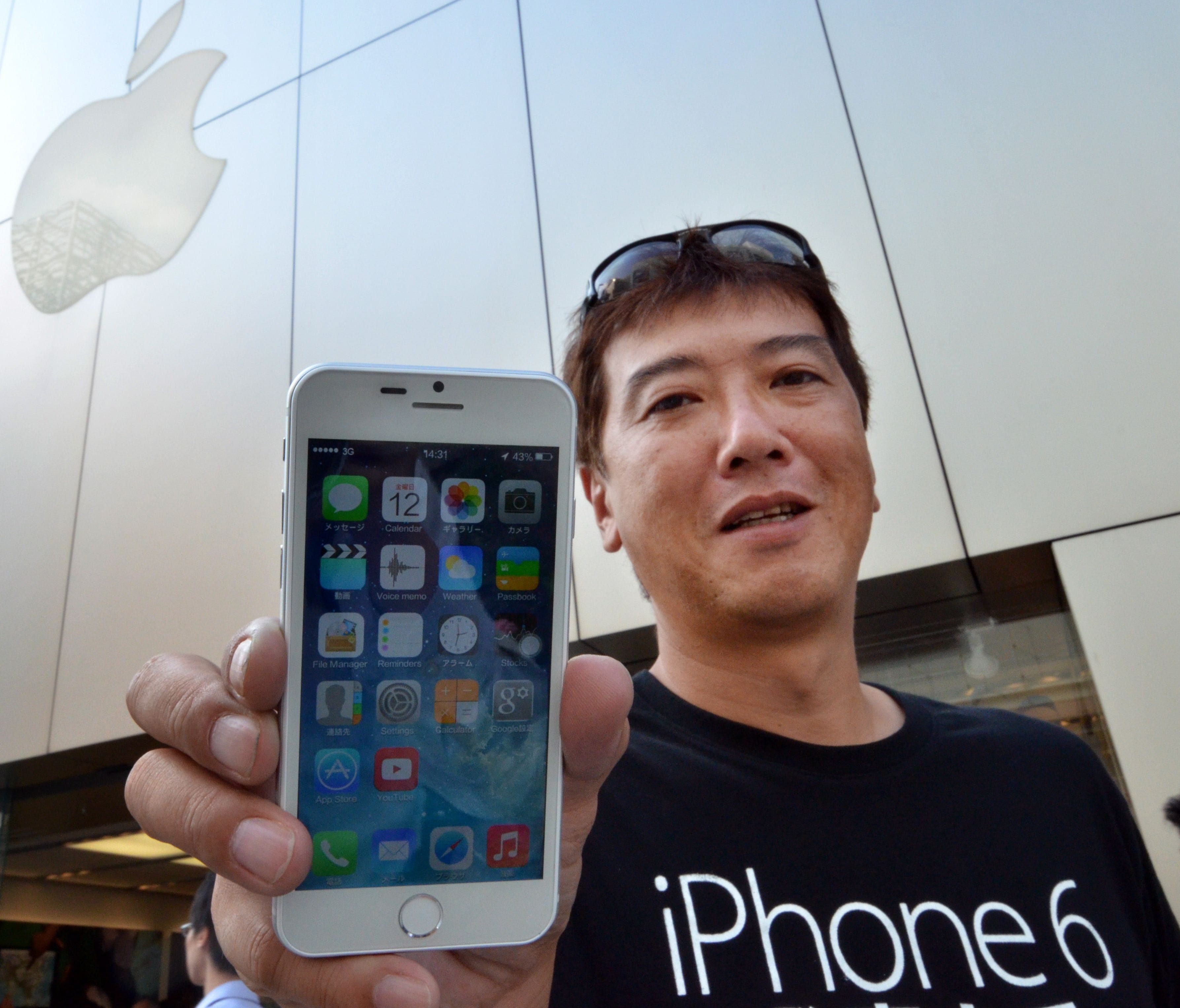 Apple fan Tetsuya Tamura holds a China made 