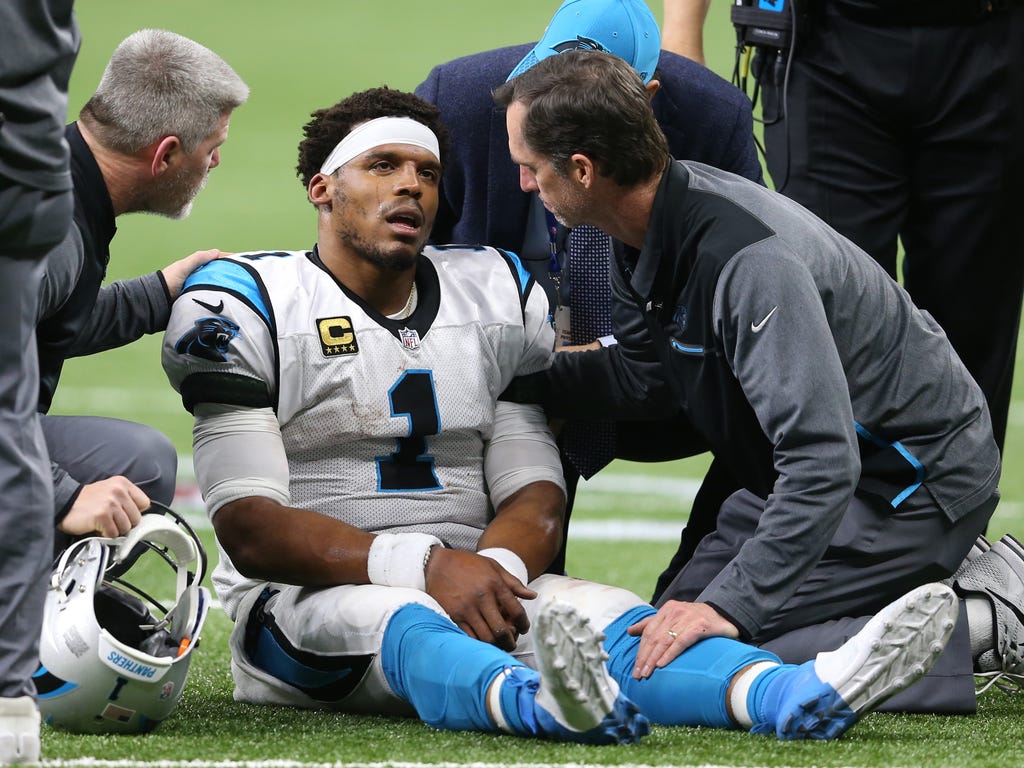 Carolina Panthers quarterback Cam Newton is examined after being tackled by the New Orleans Saints during the fourth quarter in the NFC Wild Card playoff football game at Mercedes-Benz Superdome in New Orleans.