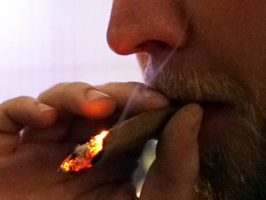A marijuana user smokes a joint of Colorado-legal cannabis