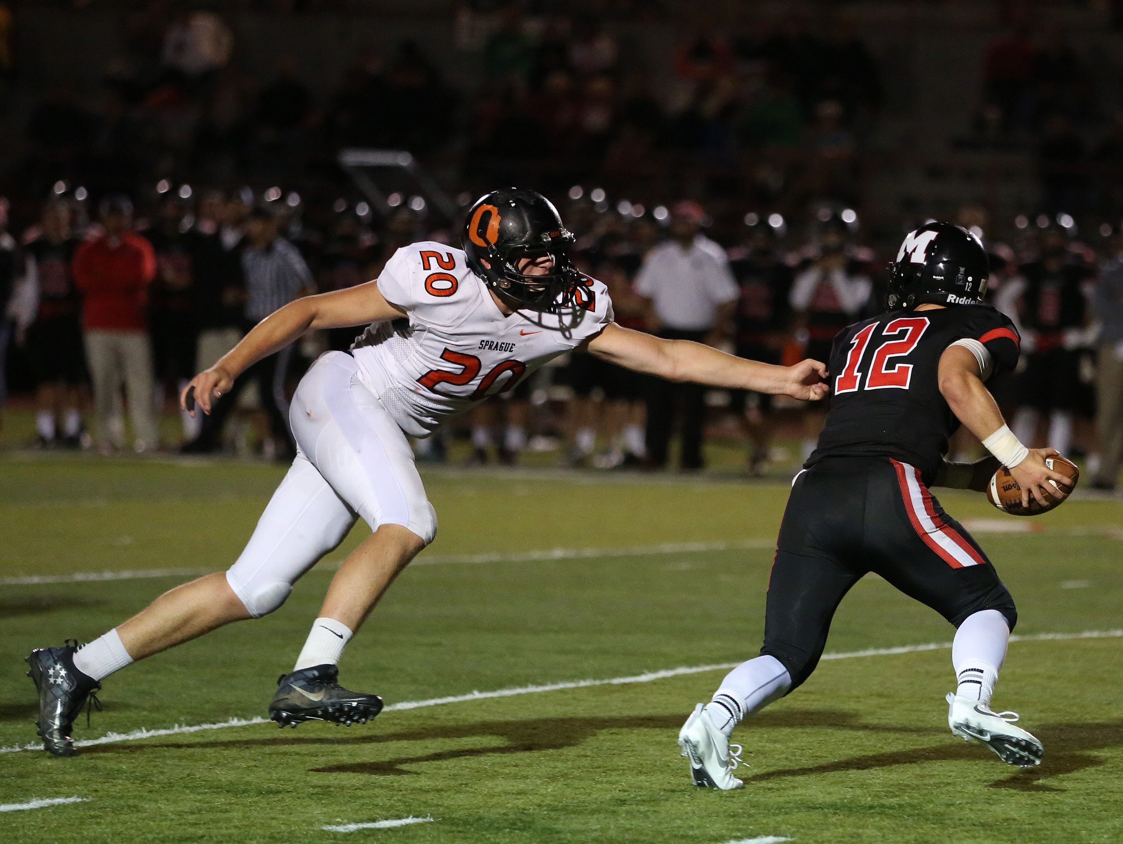 Sprague's Teagan Quitoriano goes after McMinnville's Wyatt Smith as the Olys defeat the Grizzlies 49-27 in Greater Valley Conference game on Friday, Sept. 23, 2016, in McMinnville.