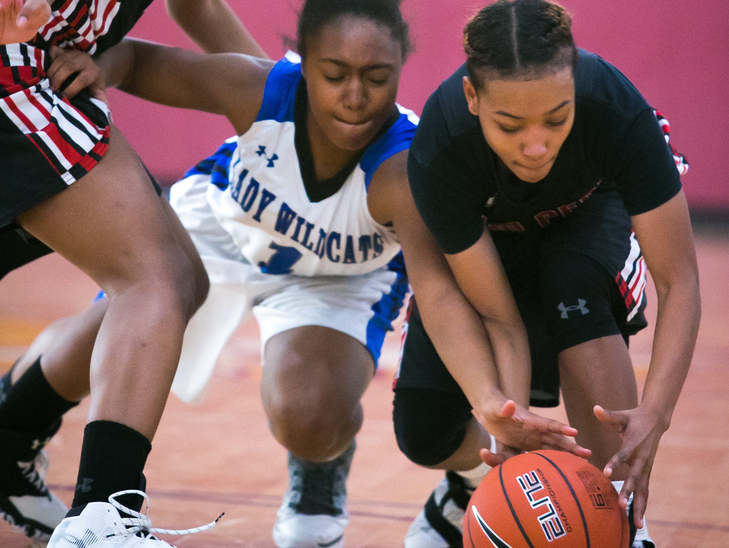 William Penn Micah Yarbray (left) and teammate Alize Felton battle for the loose ball with Howard guard Na'Leigha Wright battles for the loose ball in the second half. William Penn loses to Howard high with a final score of 43-32.