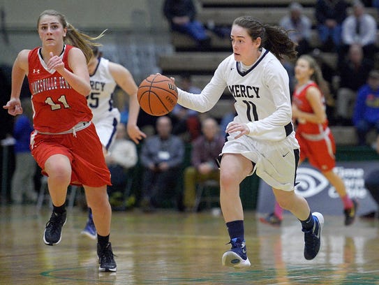 Mercy's Abby Purcell, right, dribbles up court on a