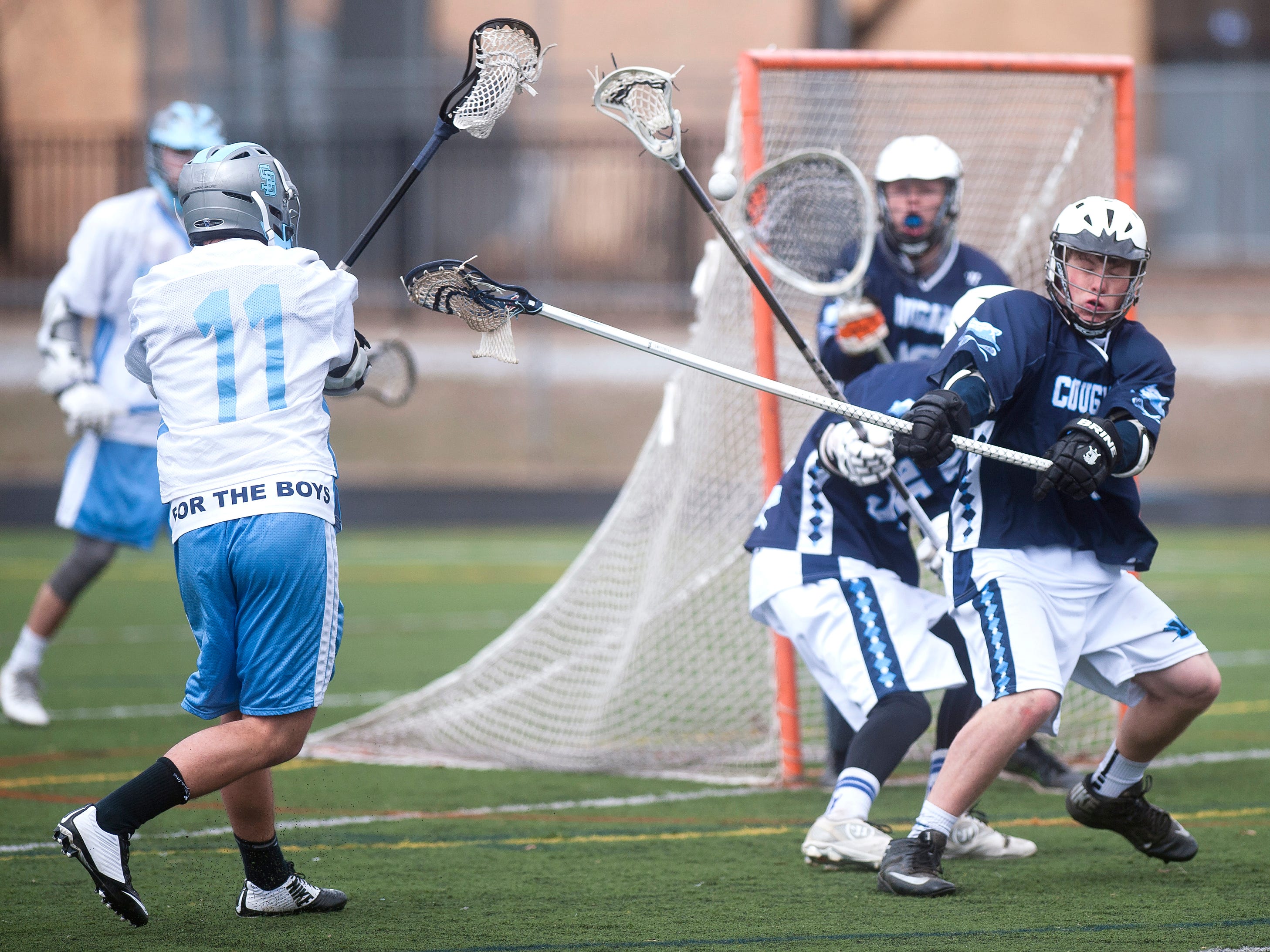 South Burlington attacker Ben Sievers (11) rifles a shot at the Mount Mansfield goal during the fourth quarter of Saturday's boys lacrosse game in South Burlington.