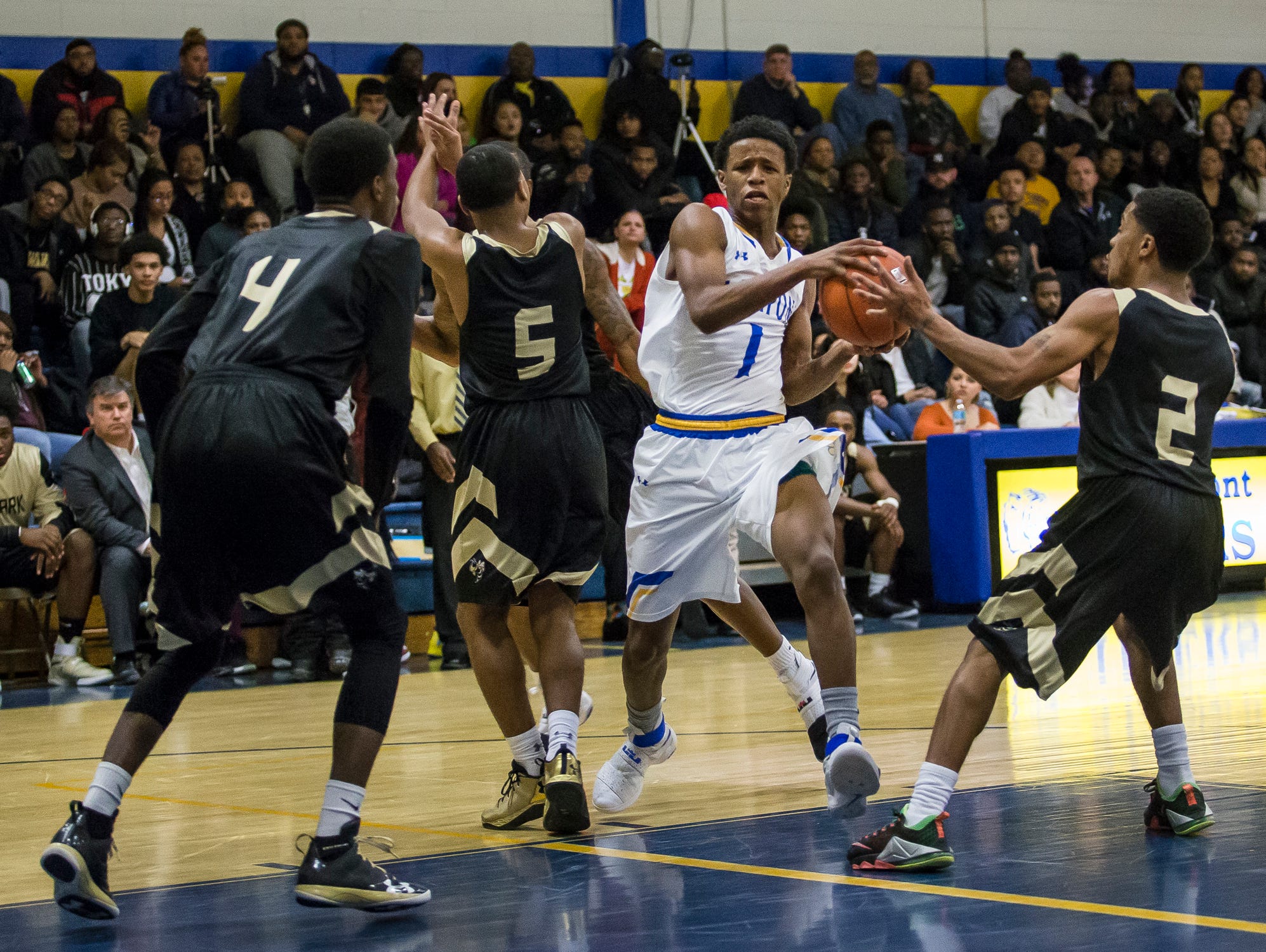 A.I.'s Julius Inge (No. 1) cuts through a group of Newark defenders in the first quarter of Newark's 52-51 win over A.I. duPont High School in Greenville on Tuesday evening.