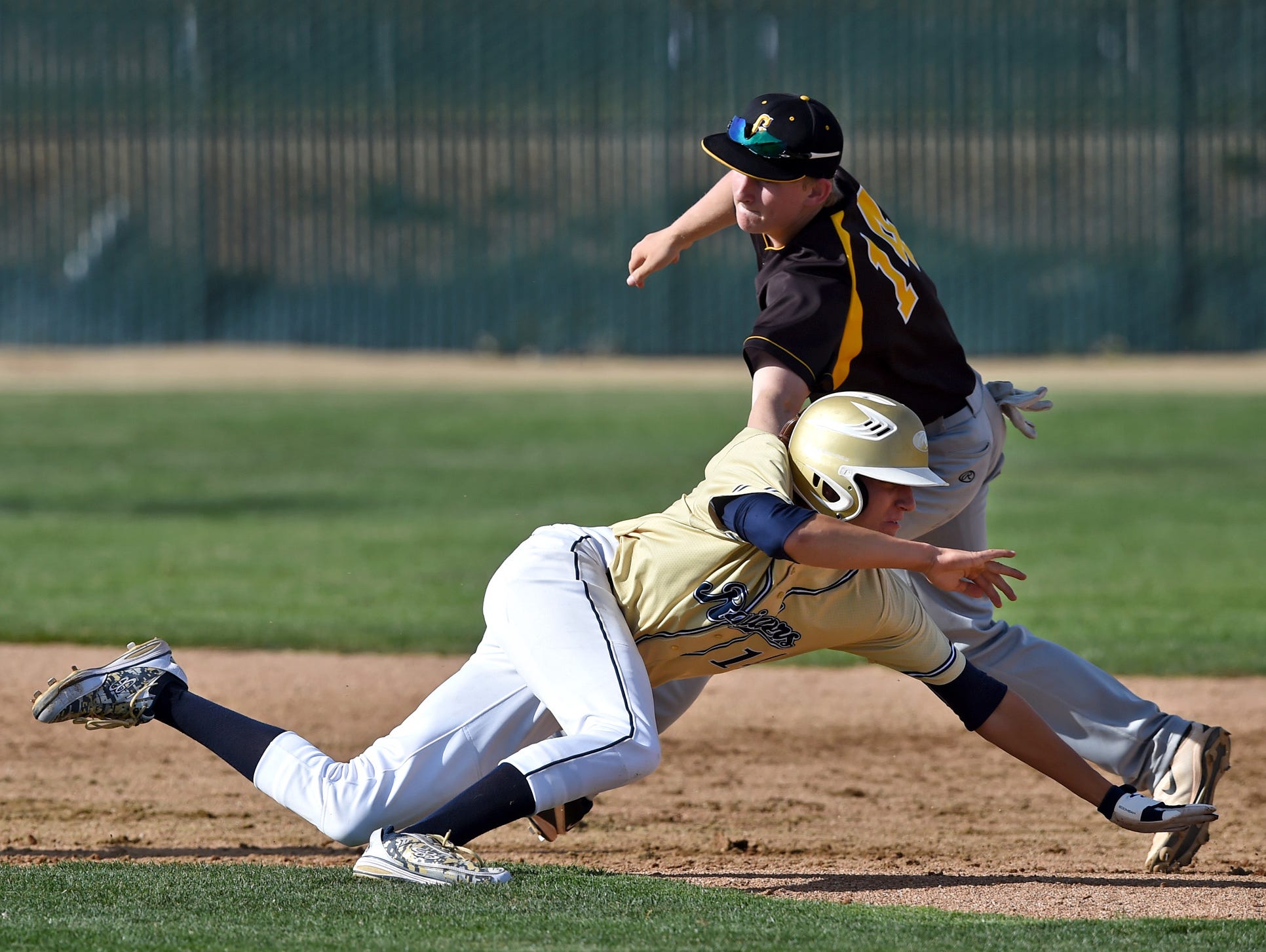 Galena's Andrew West reaches to tag Reed's Levi Sanchez who was caught in a rundown between second and third base during Tuesdays game at Reed.
