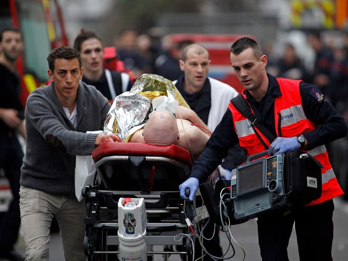 An injured person is evacuated outside the French satirical