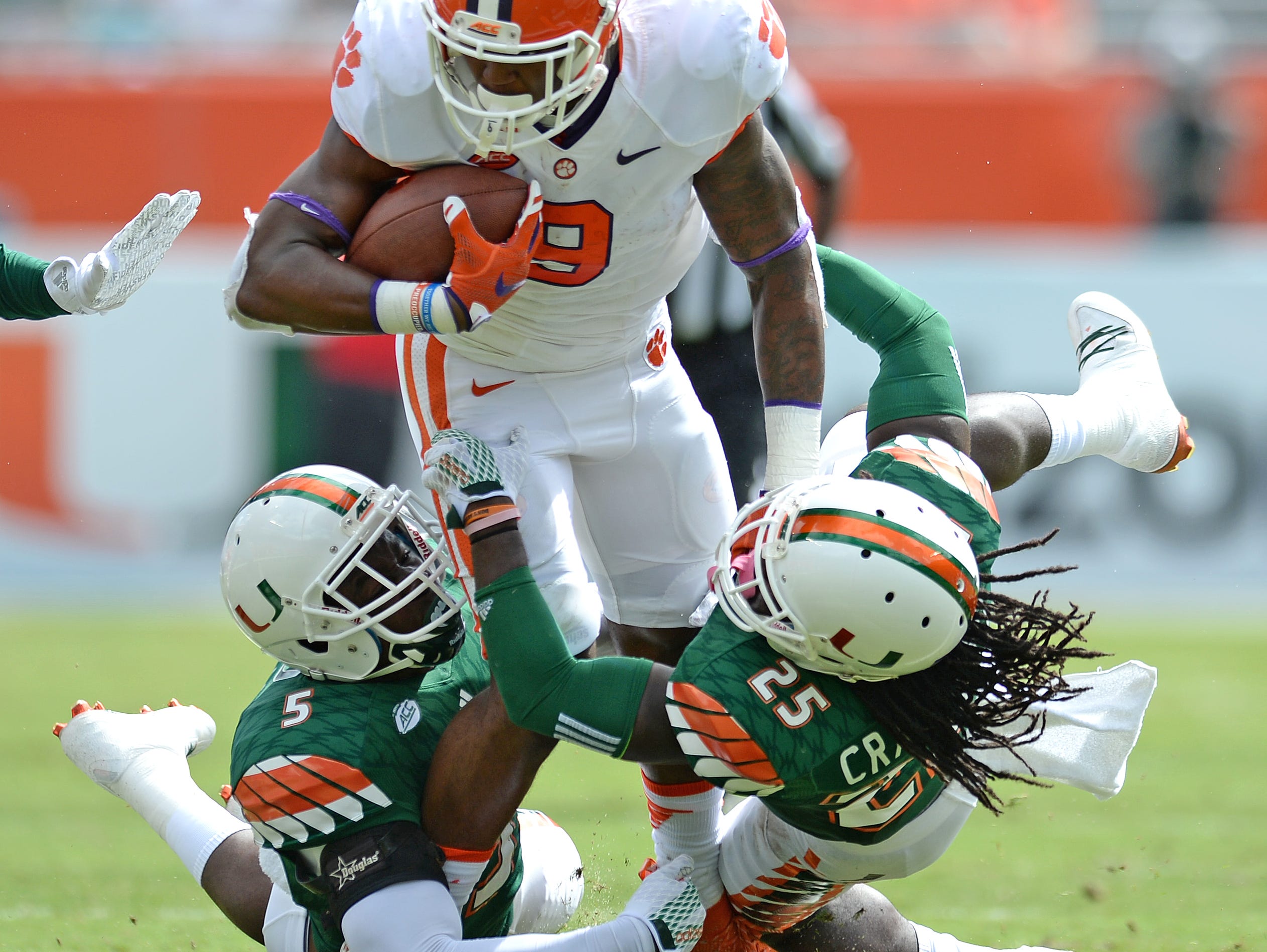 Miami linebacker Jermaine Grace (5), left, and defensive back Dallas Crawford (25) try to bring down Clemson running back Wayne Gallman (9) during the 1st quarter Saturday, Oct. 24, 2015, in Miami Gardens, Fla.
