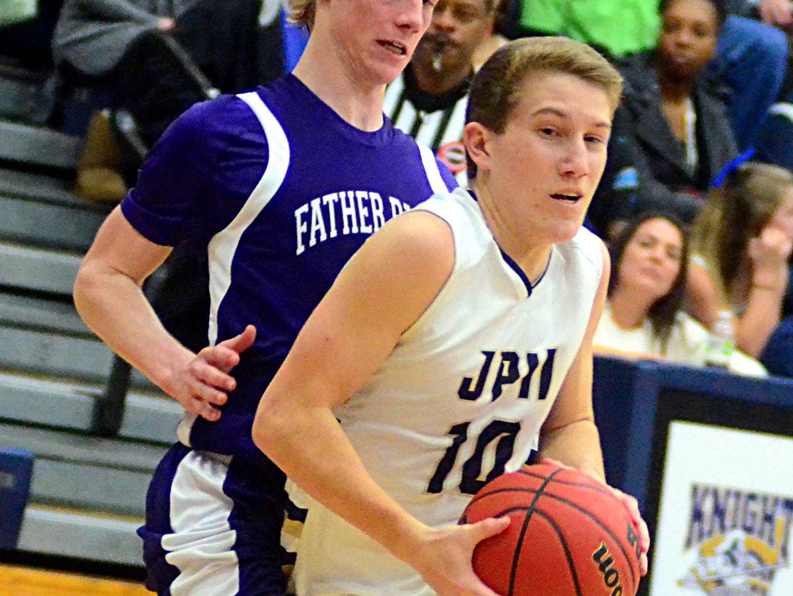 Pope John Paul II High sophomore Grayson Lang drives into the lane against Father Ryan senior Chris Camp during third-quarter action.