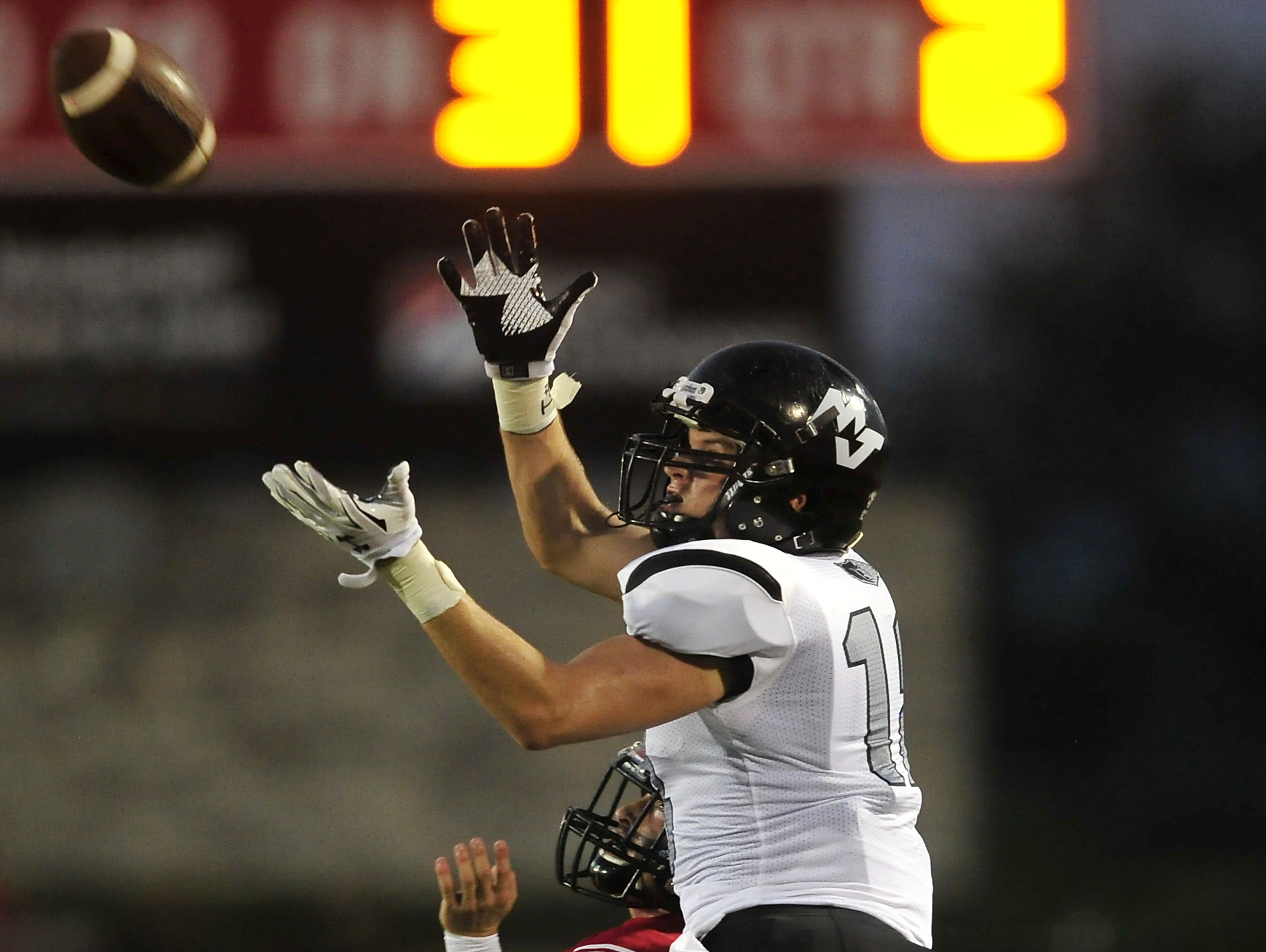Mt. Juliet's Trey Pruitt (18) catches a pass over Ravenwood's Zack Stallcup during the first half at Ravenwood High School in Brentwood, Tenn., Friday, Sept. 4, 2015.
