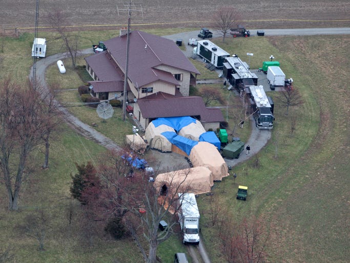 FBI agents on April 2, 2014, work around a home in Rush County, Ind., to confiscate thousands of artifacts from Native Americans, Russia, China, and other nations from a private collection.