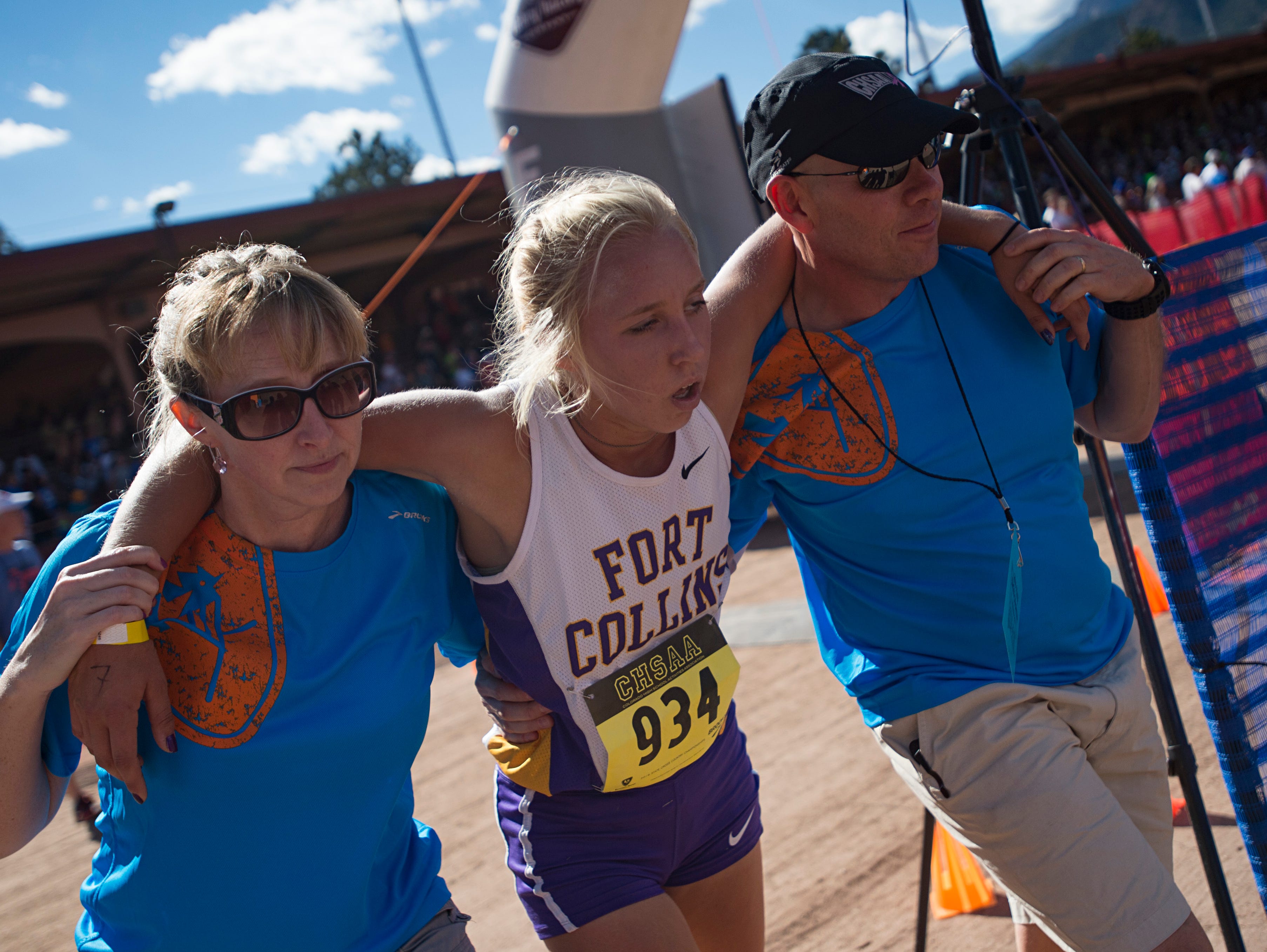 Fort Collins High School runner and defending champion Lauren Gregory is helped by officials after crossing the finish line in the CHSAA Cross Country Championship at Norris-Penrose Events Center in Colorado Springs Saturday, October 29, 2016. Gregory finished second.