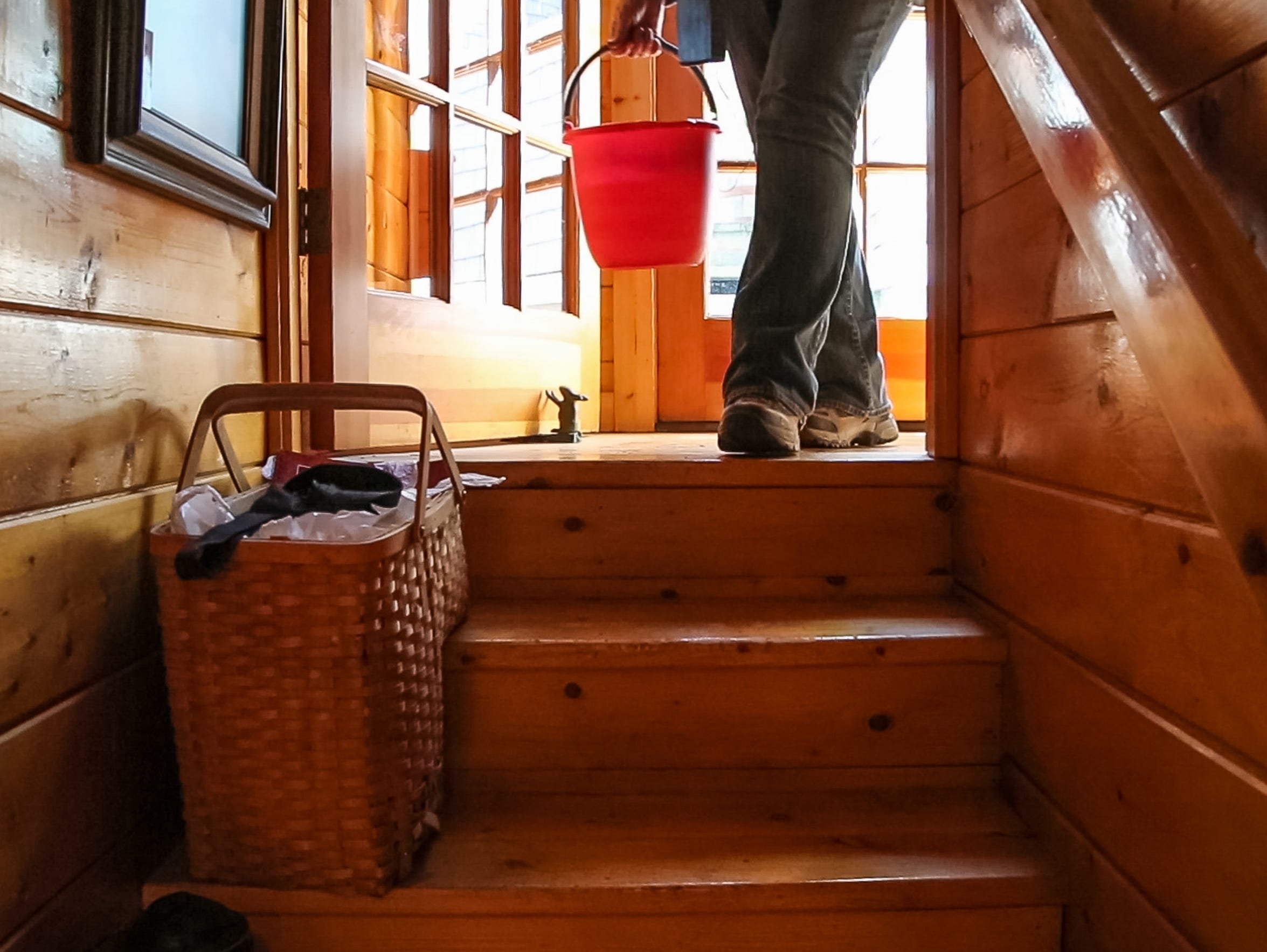 Sharon Bailey carries a bucket of water she collected