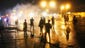 Police fire tear gas at demonstrators.