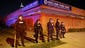 Police stand outside a shuttered store, Monday, April