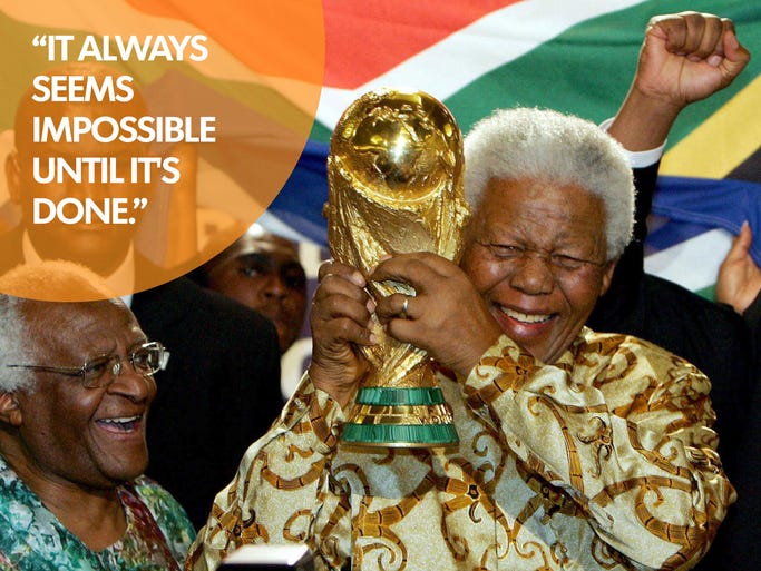 Former South African President Nelson Mandela holds the Jules Rimet World cup beside Capetown Archbishop Desmond Tutu, at the FIFA headquarters in Zurich on May15, 2004.