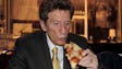 Mike Ilitch  enjoys a slice of Little Caesar's pizza