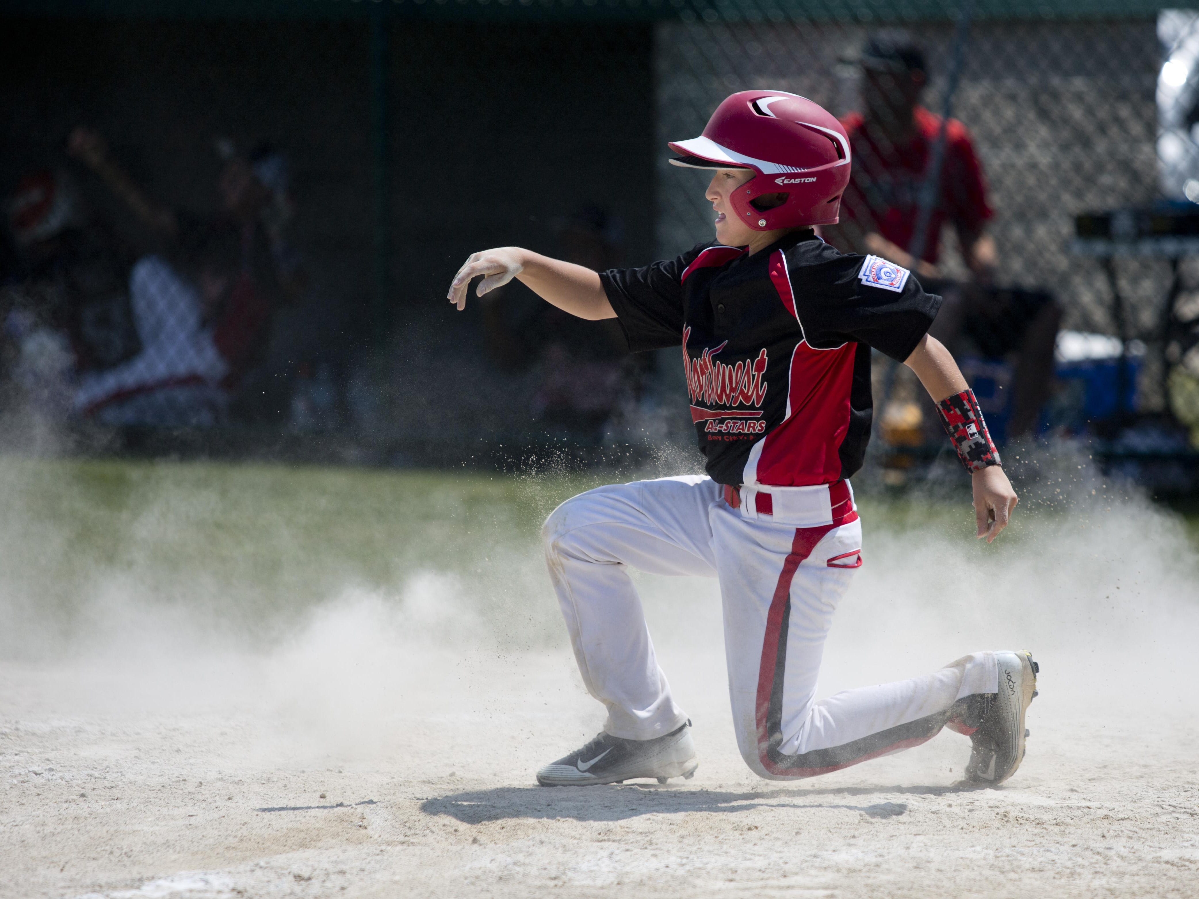 Bay City Northwest's Lucas Julian slides into home to score Wednesday in St. Clair.