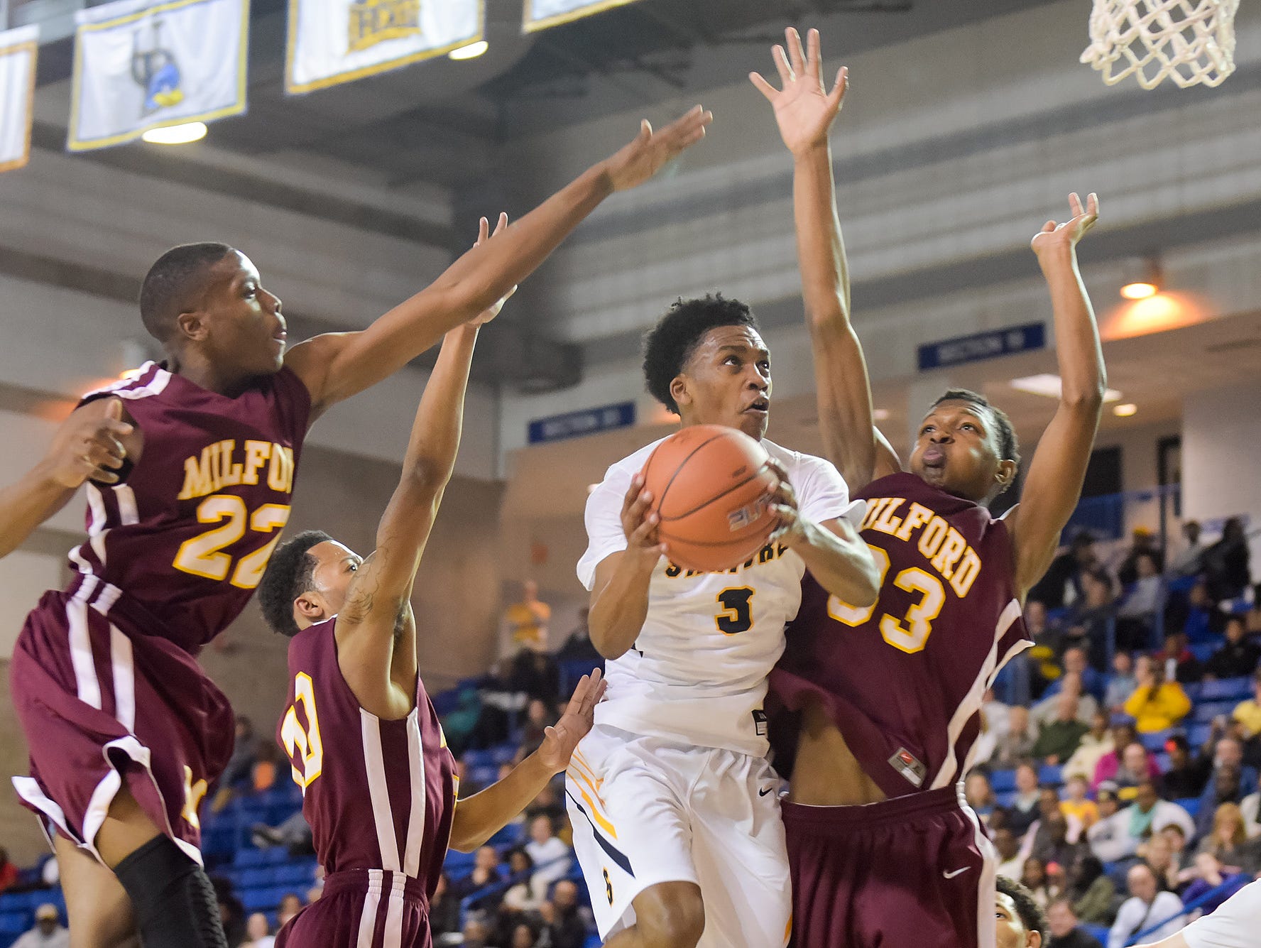 Sanford's Mikey Dixon drives against Milford's Eugene Riley (33) in last Sunday's DIAA Boys Basketball Tournament quarterfinals.