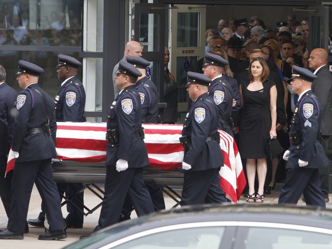 Amy Pierson watches as her husband's casket is brought back to the hearse after the service.