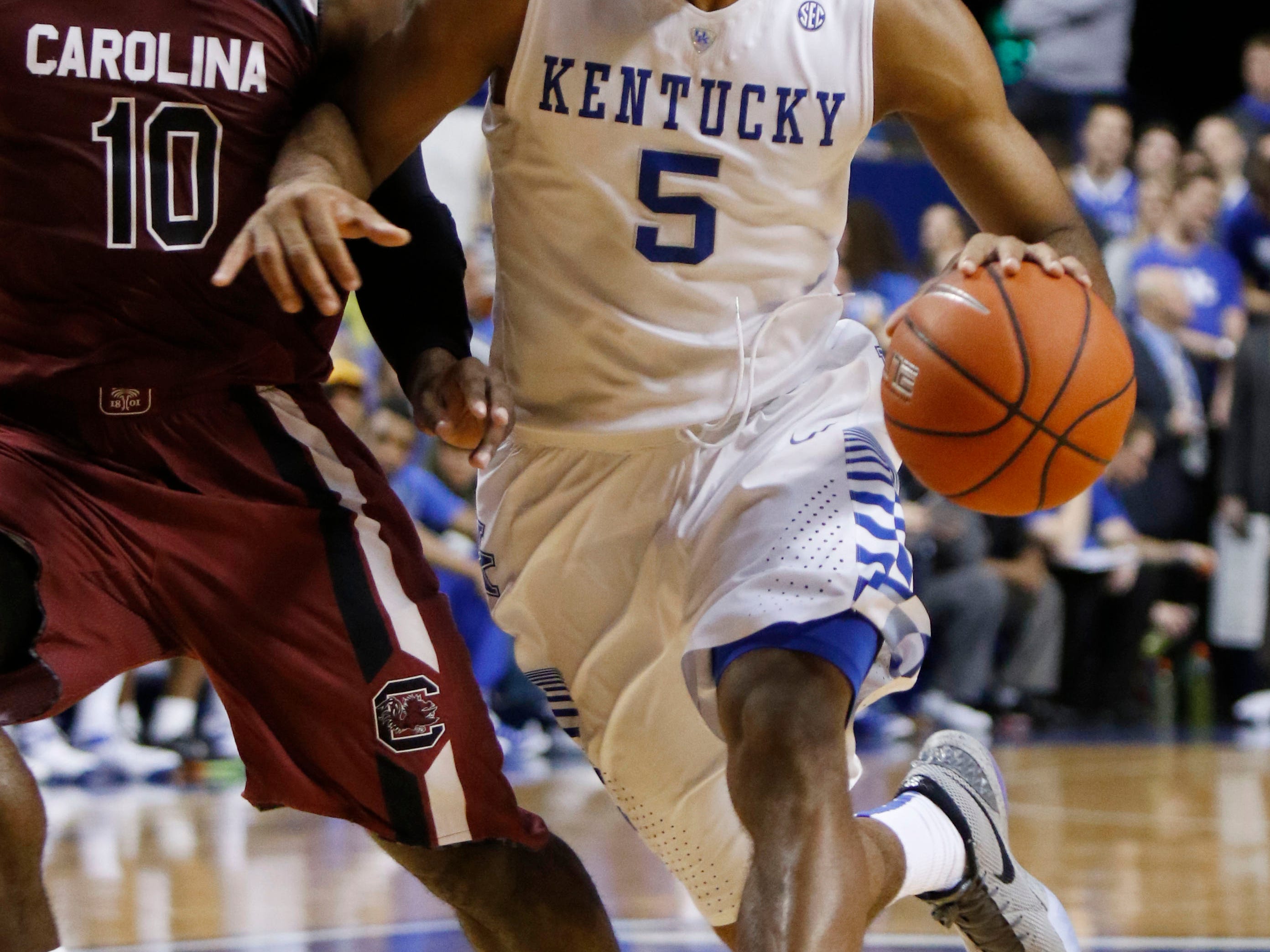 Kentucky's Andrew Harrison (5) is guarded by South Carolina's Duane Notice (10) during the first half of an NCAA college basketball game, Saturday, Feb. 14, 2015, in Lexington, Ky. (AP Photo/James Crisp)
