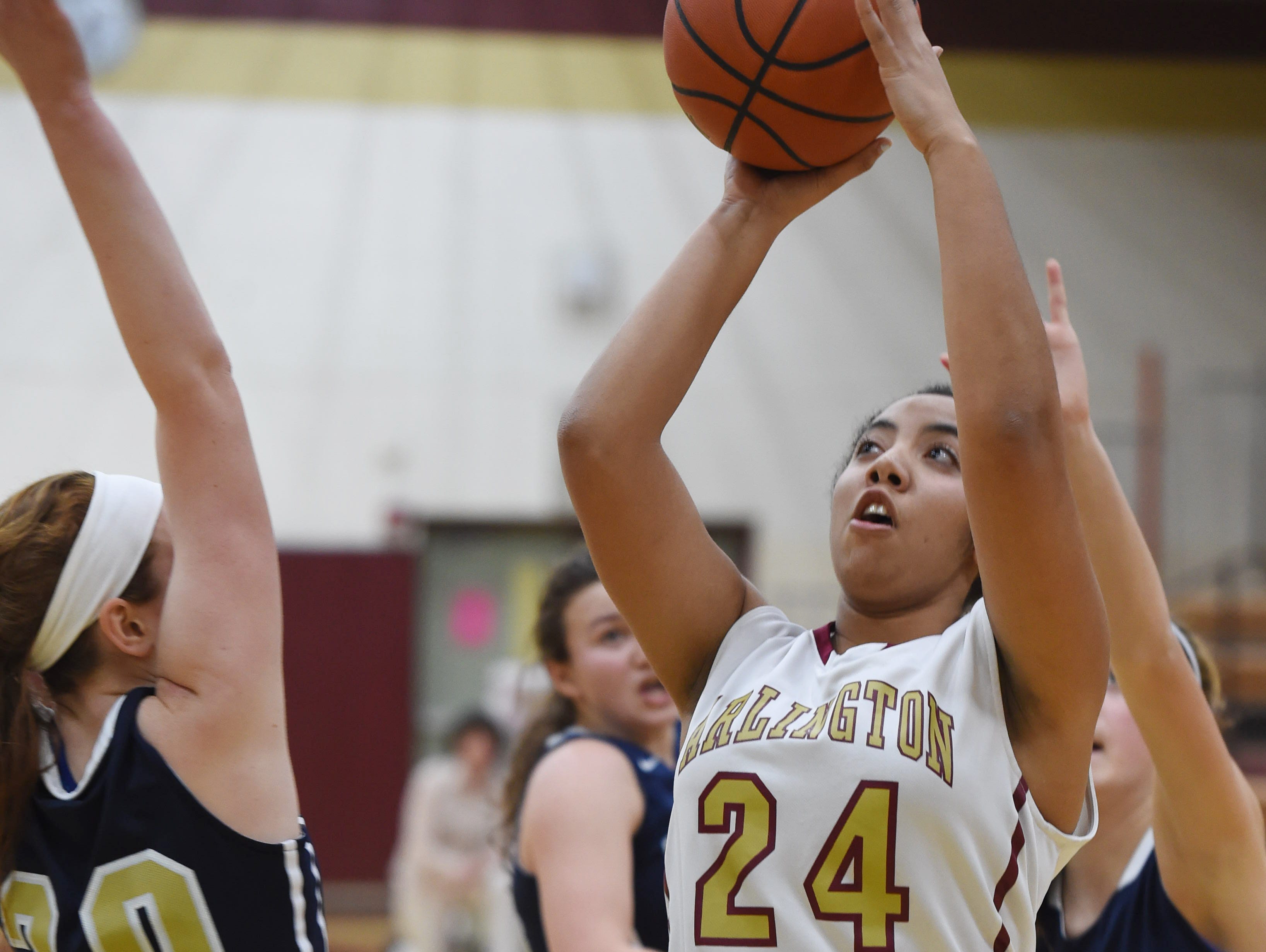 Arlington's Tiana Johnson takes a shot as Lourdes' Marguerite McGahay covers her during Wednesday's game at Arlington.