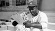 Montreal Royals player Jackie Robinson looks over a