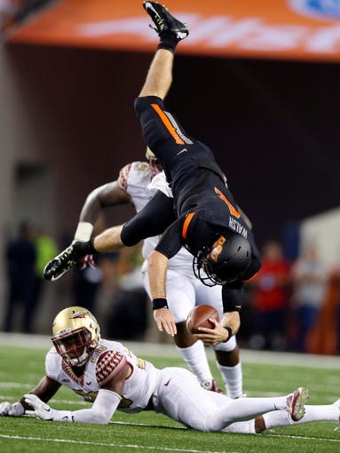 Florida State defender P.J. Williams, bottom, upends Oklahoma State quarterback J.W. Walsh on a fourth-quarter run.
