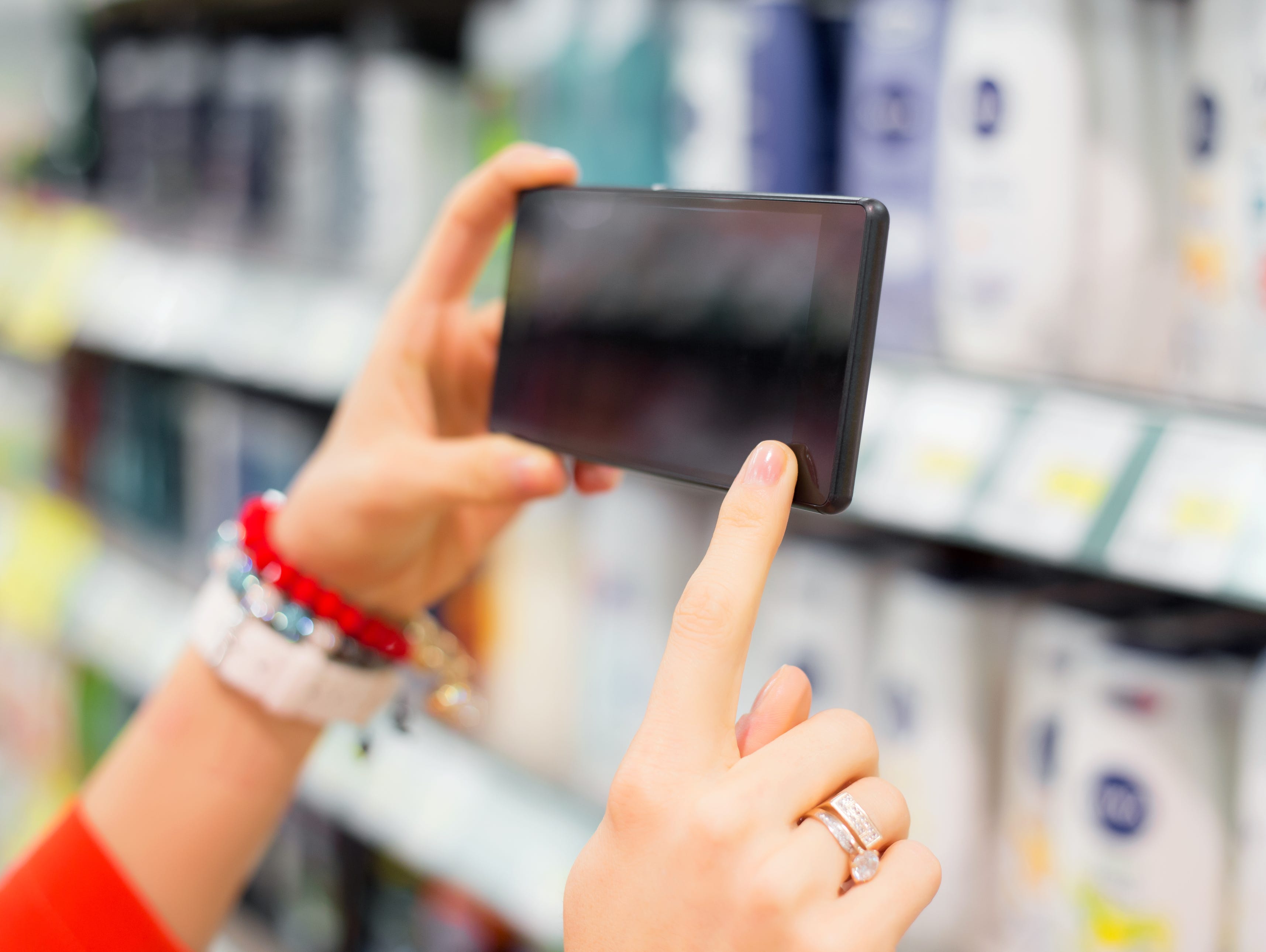 Woman taking picture in supermarket
