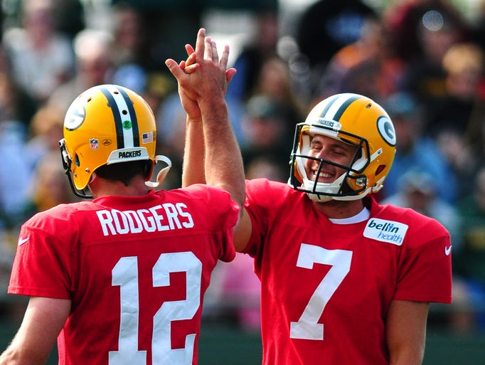 Green Bay Packers quarterback Chase Rettig gets a high-five from quarterback Aaron Rodgers during training camp practice at Ray Nitschke Field, Monday, July 28, 2014.