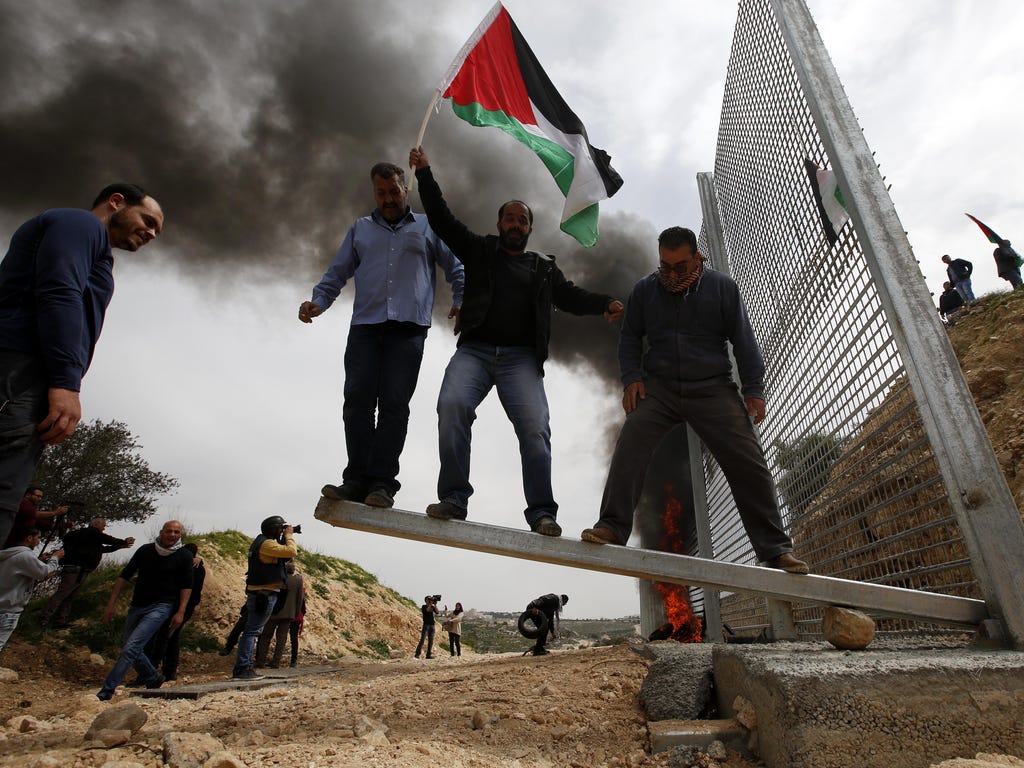 Palestinians try to bring down the Israeli fence during a protest to mark land day in the West Bank city of Biet Jala. On March 30, 1976, Palestinians declared a general strike and held large demonstrations against land expropriations by Israeli auth