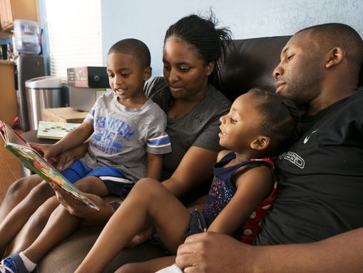 The Corley family reads a book at their home in Surprise.