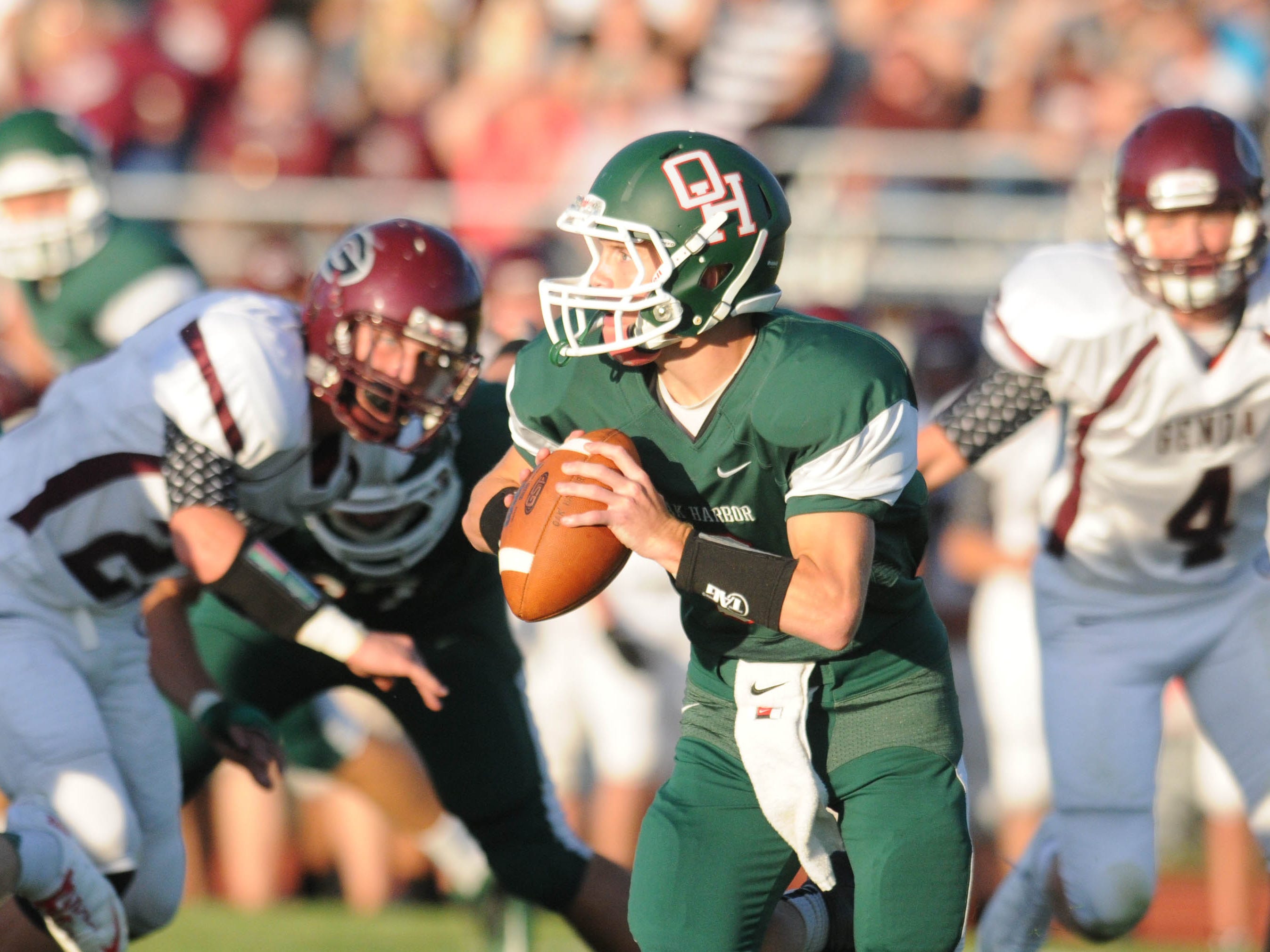 Oak Harbor's Cole Weirich is chased by the Genoa defense as he looks to throw during the first half of a football game on Friday, Sept 6, 2013. Jonathon Bird/News Herald